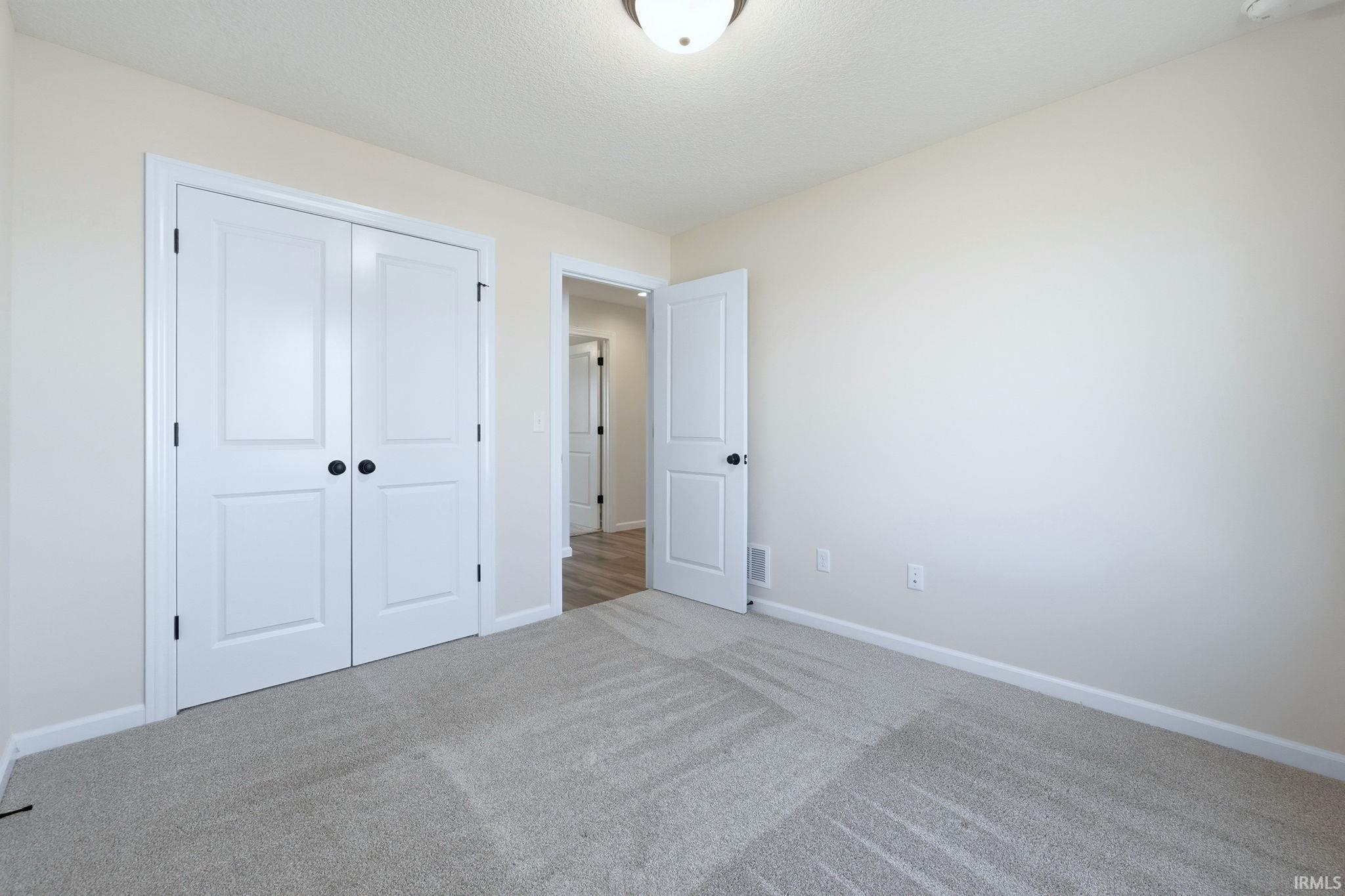 Unfurnished bedroom with carpet floors and a closet