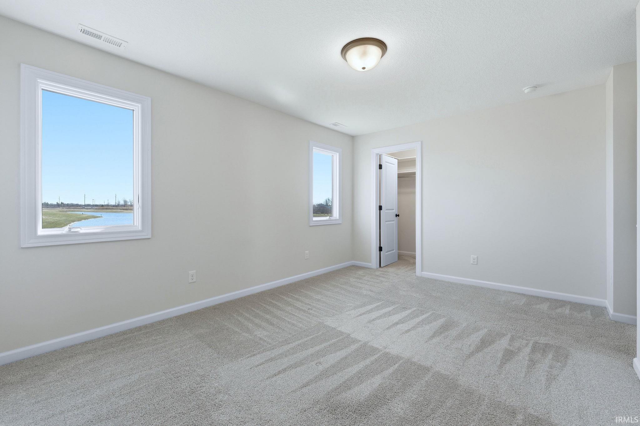 Unfurnished bedroom featuring a spacious closet and light carpet
