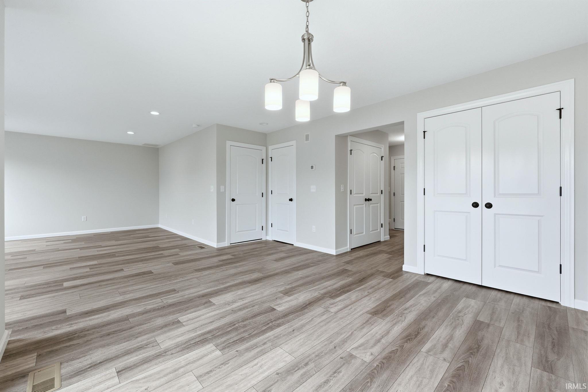 Unfurnished dining area with light wood-style flooring and a chandelier