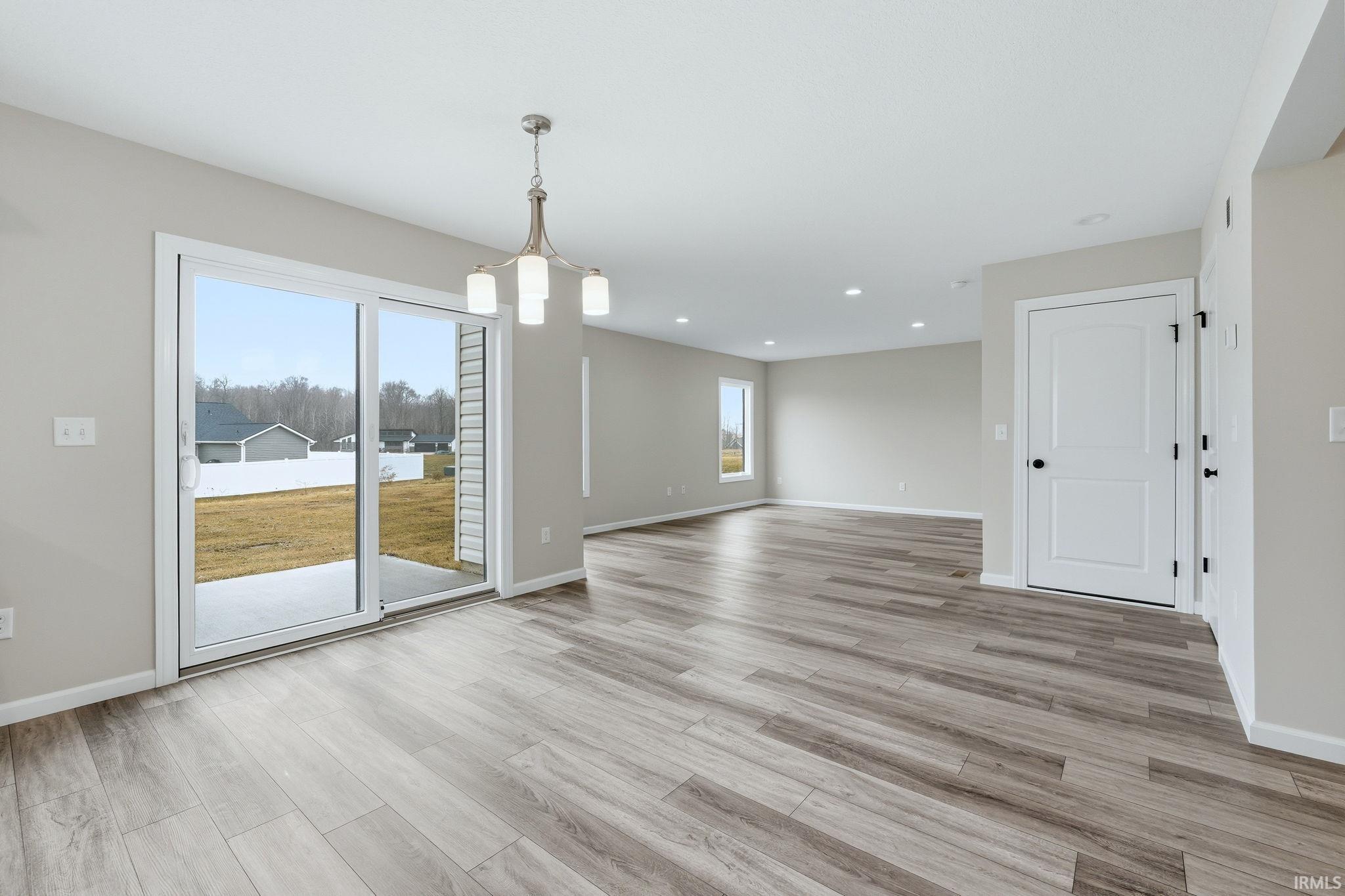 Unfurnished dining area featuring light wood finished floors and suspended lighting