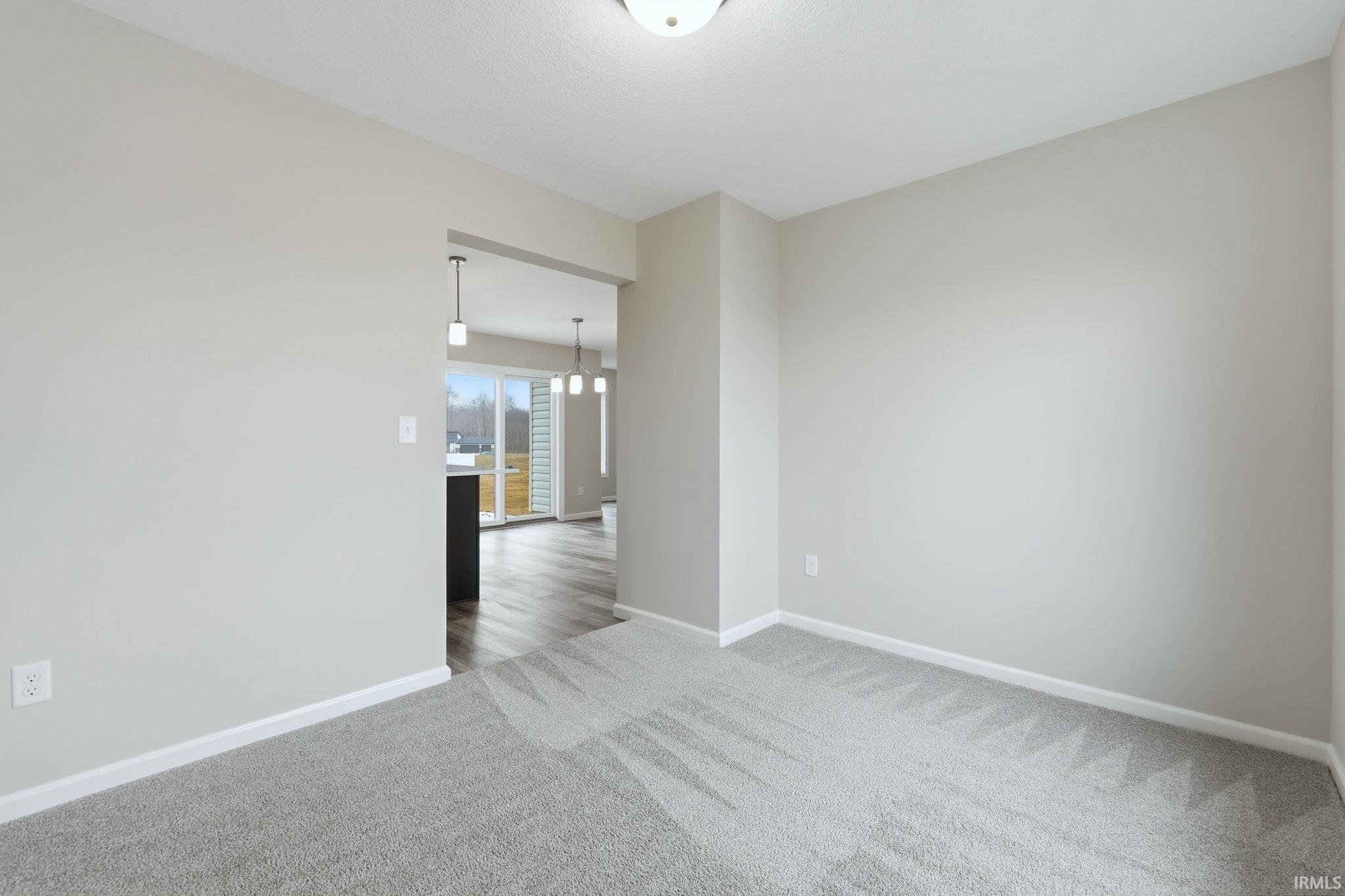 Unfurnished room with baseboards and light colored carpet