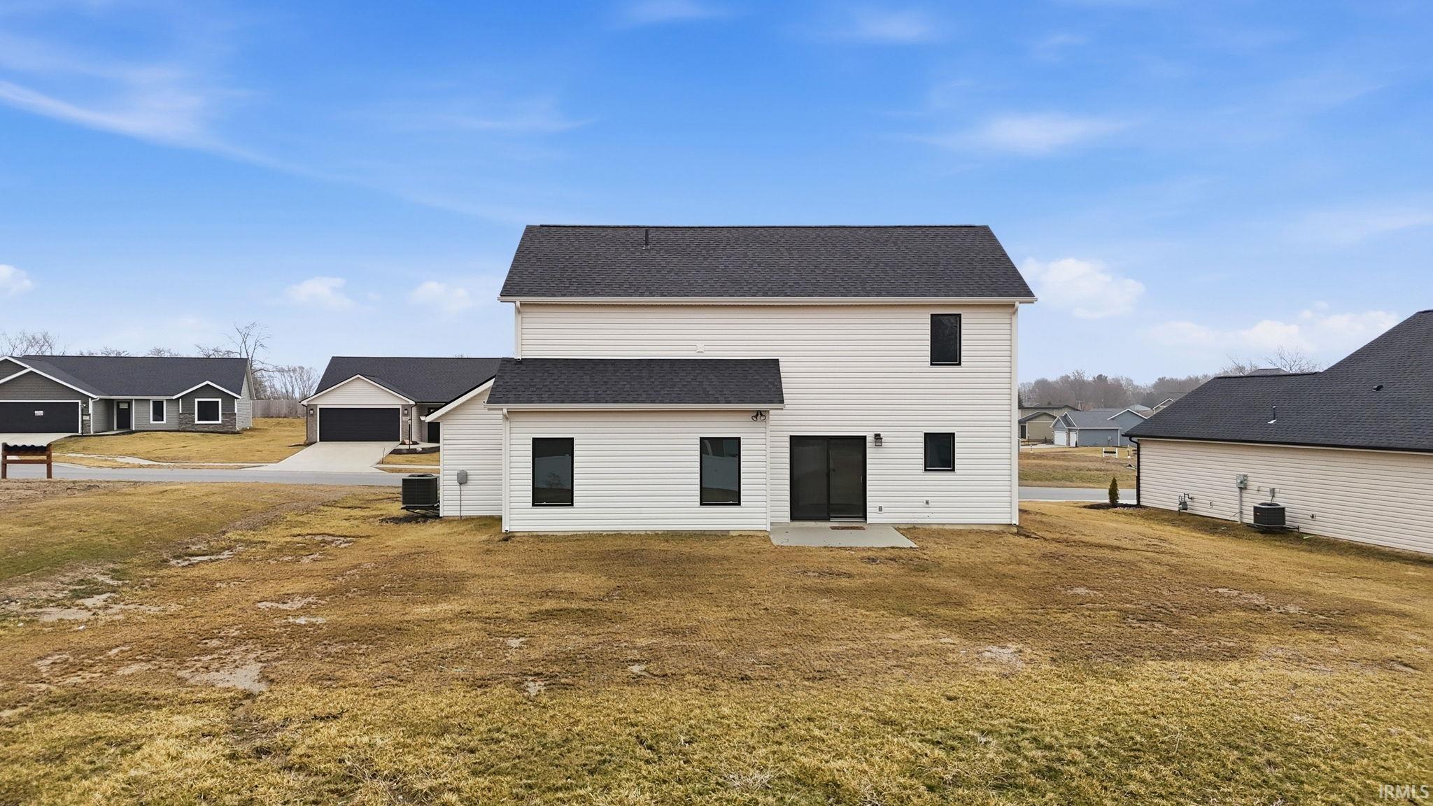 Rear view of property with a shingled roof, a residential view, a yard, and a patio area