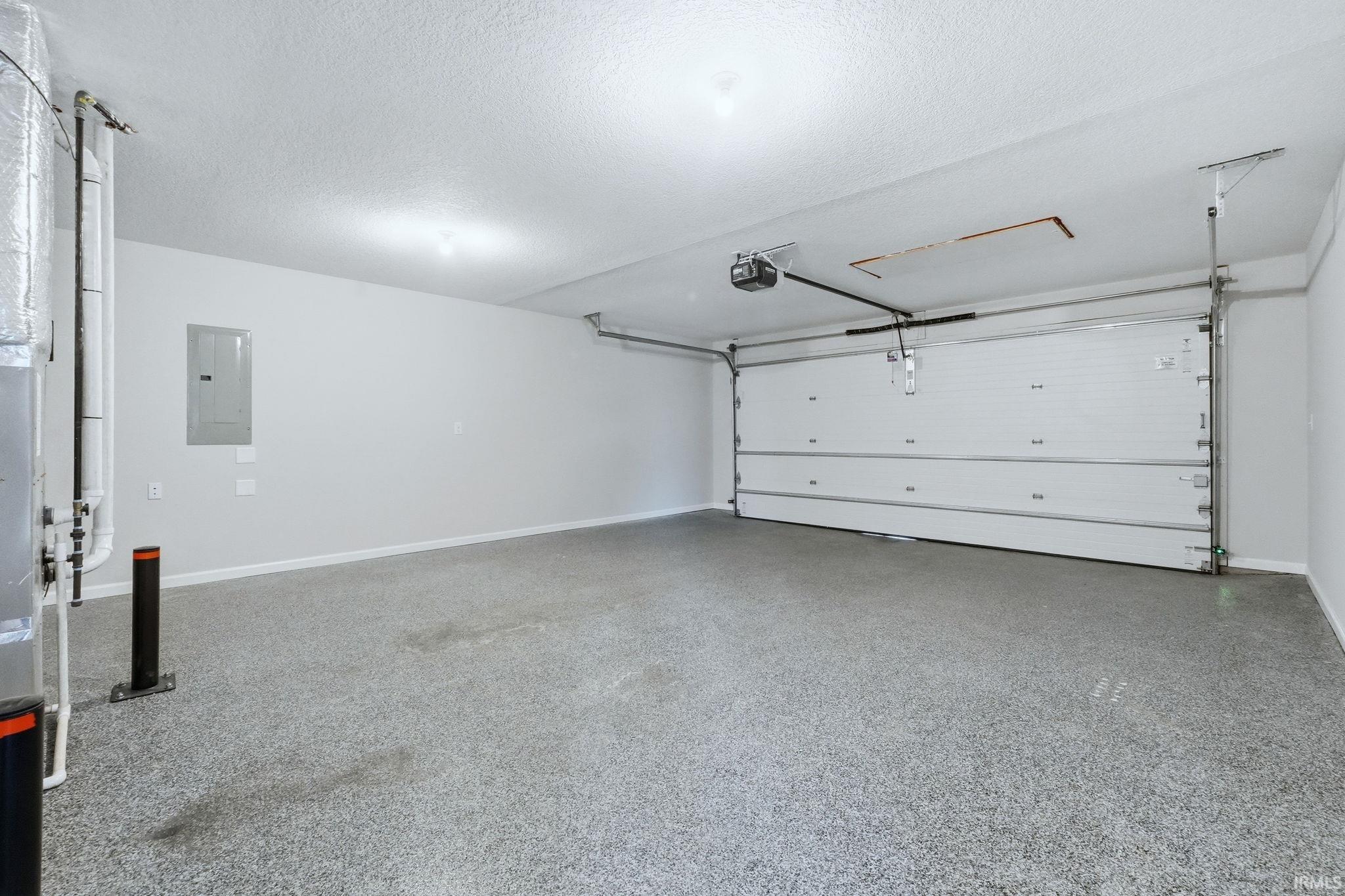 Garage featuring electric panel and a garage door opener