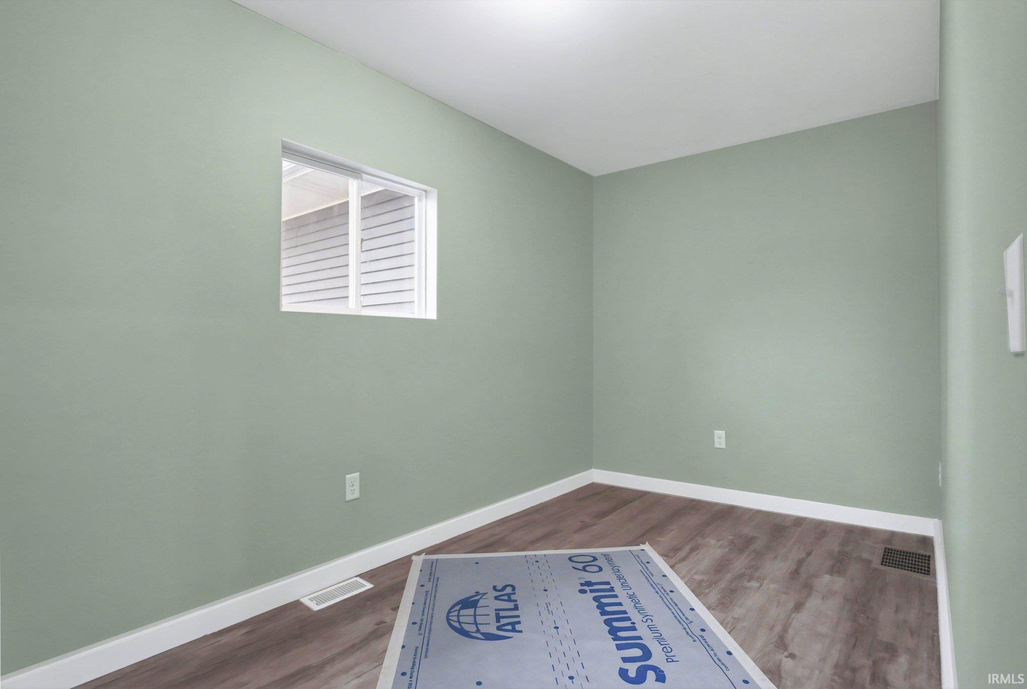 Spare room featuring dark wood-style flooring