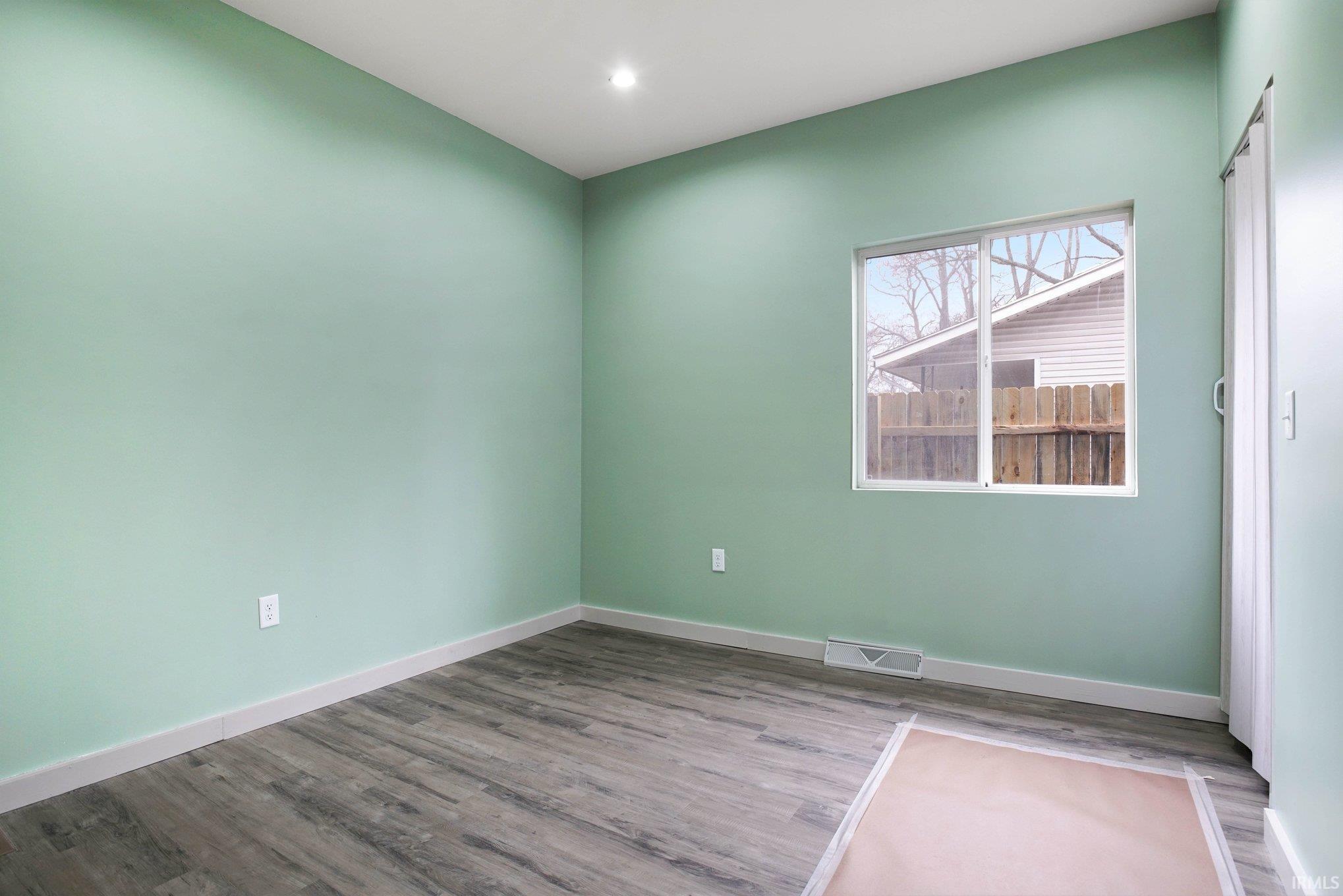 Spare room with baseboards and wood finished floors