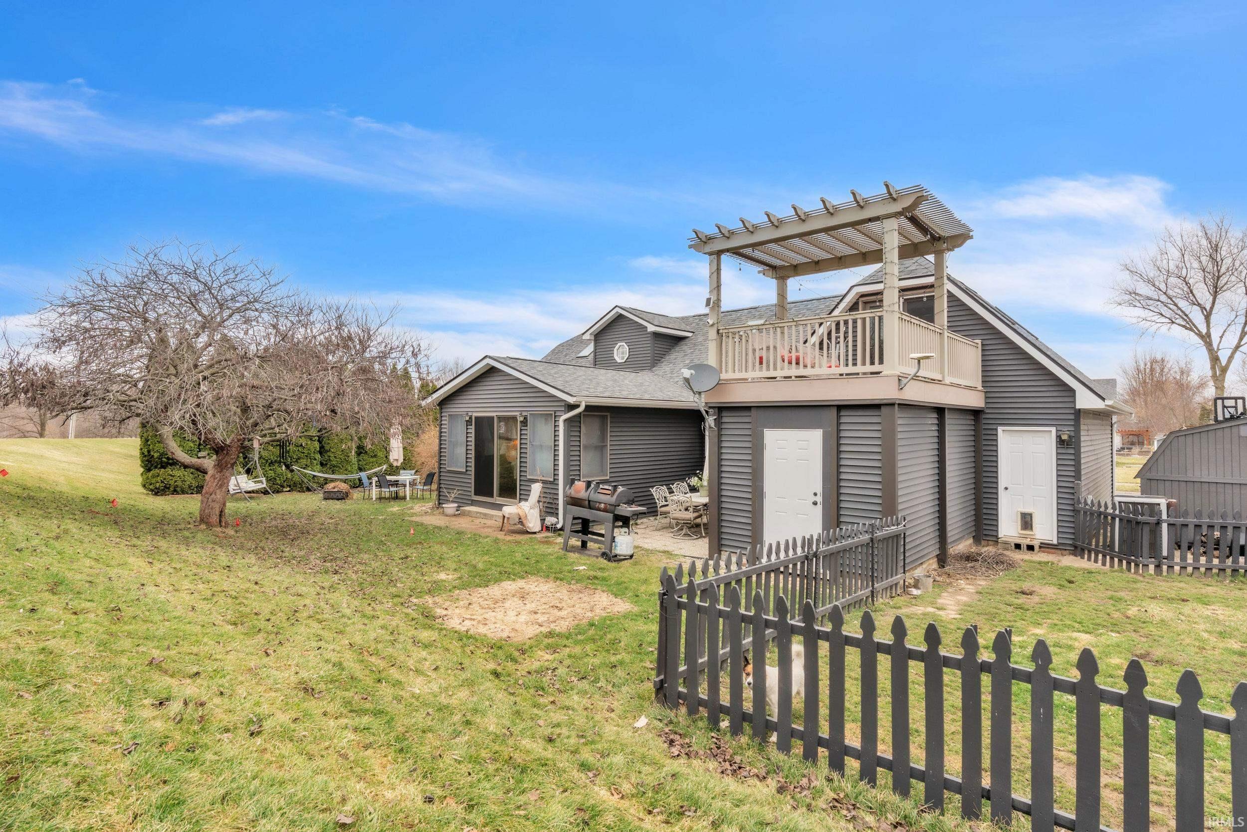 Back of property featuring a patio area, roof with shingles, and a pergola