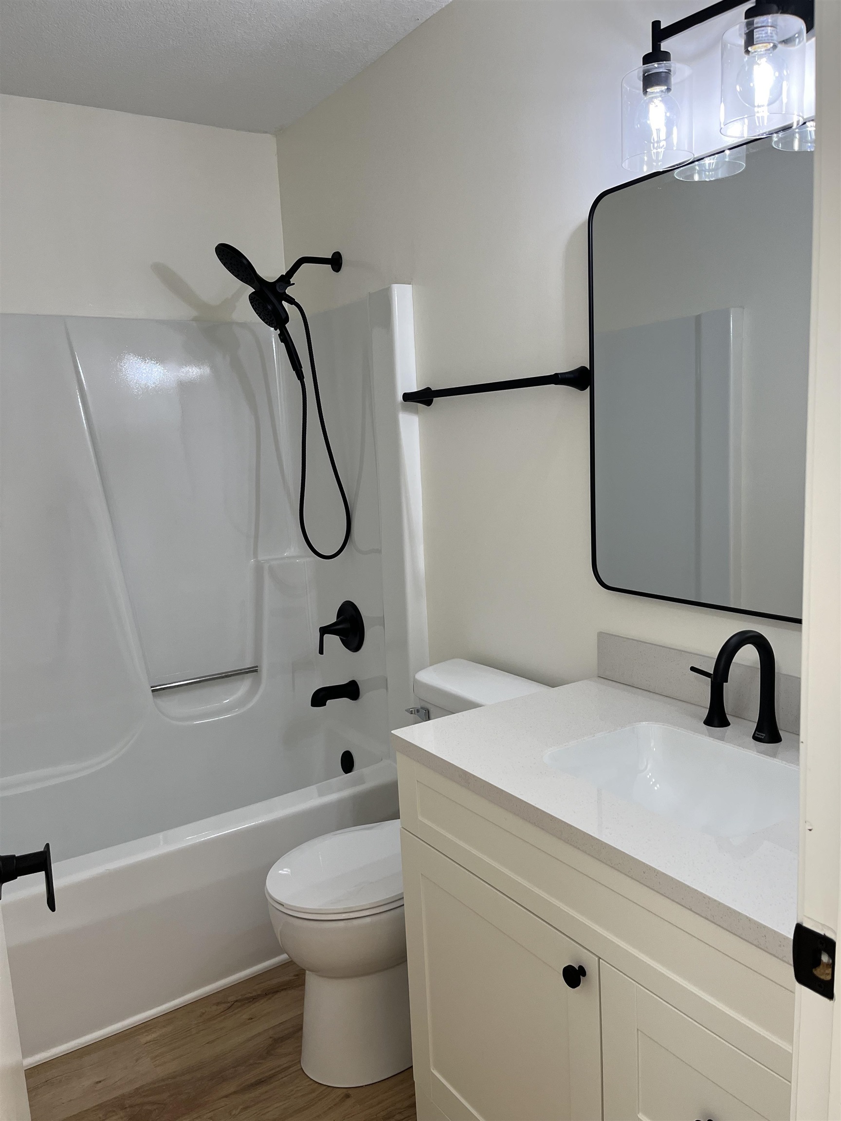 Full bath featuring vanity, shower / bathtub combination, and light wood-style flooring