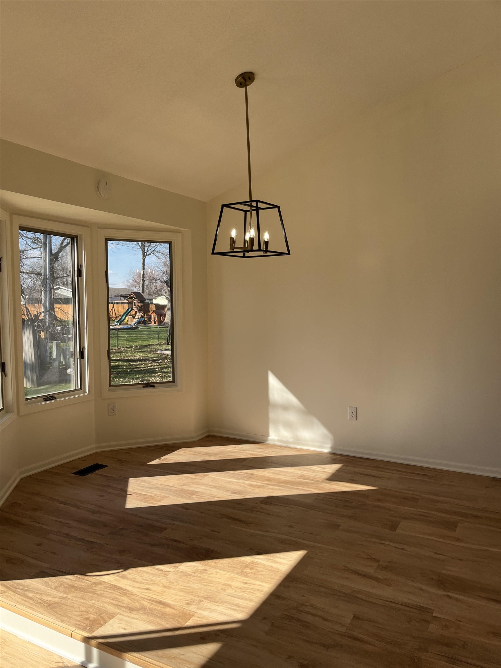 Unfurnished dining area featuring a chandelier, dark wood finished floors, and lofted ceiling