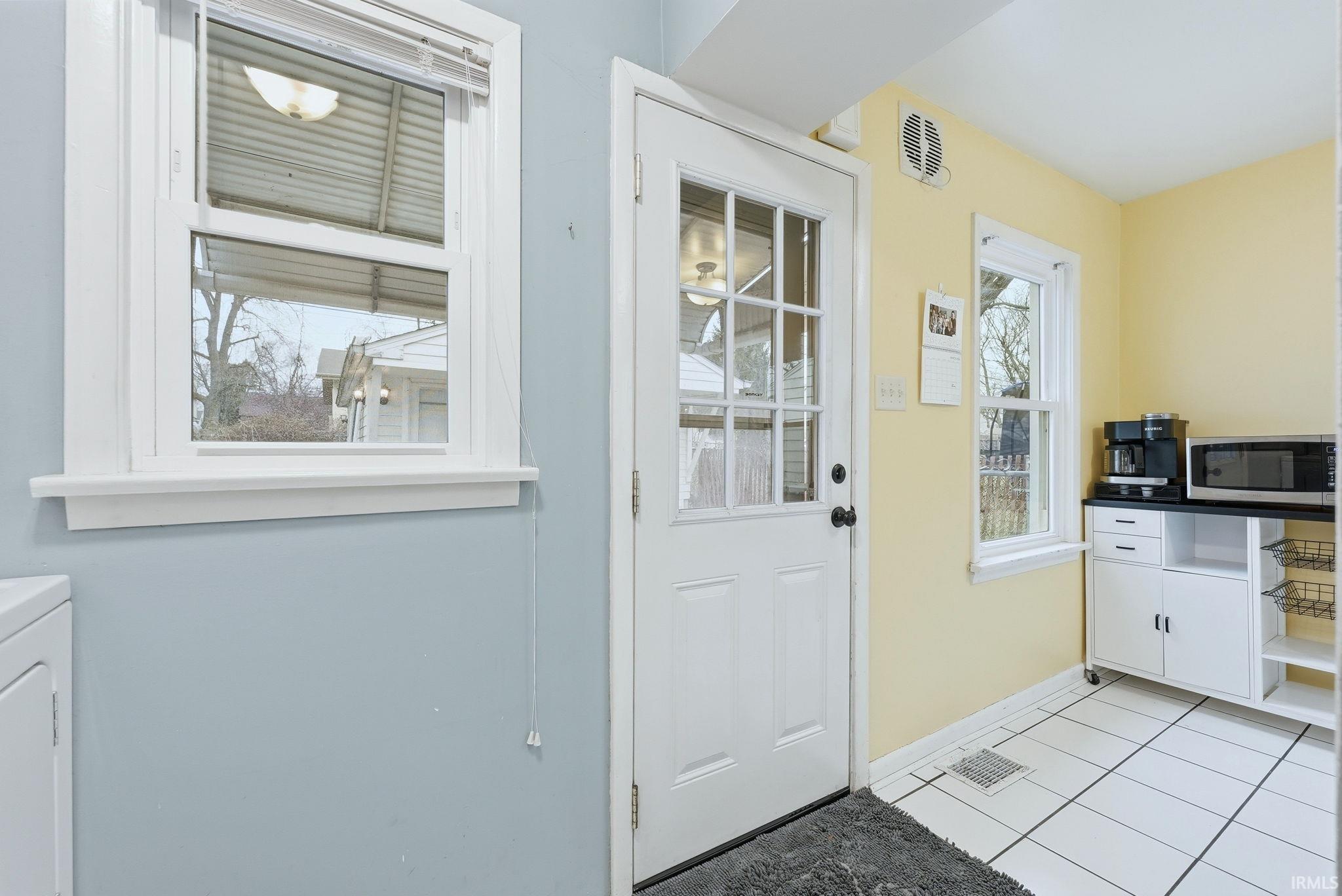 Entryway with tile patterned flooring and washer / clothes dryer