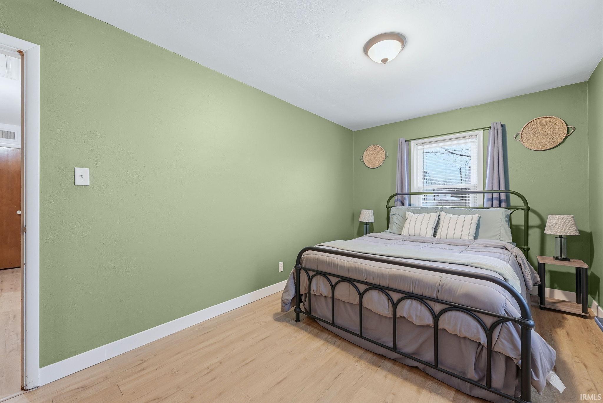 Bedroom featuring light wood finished floors and baseboards
