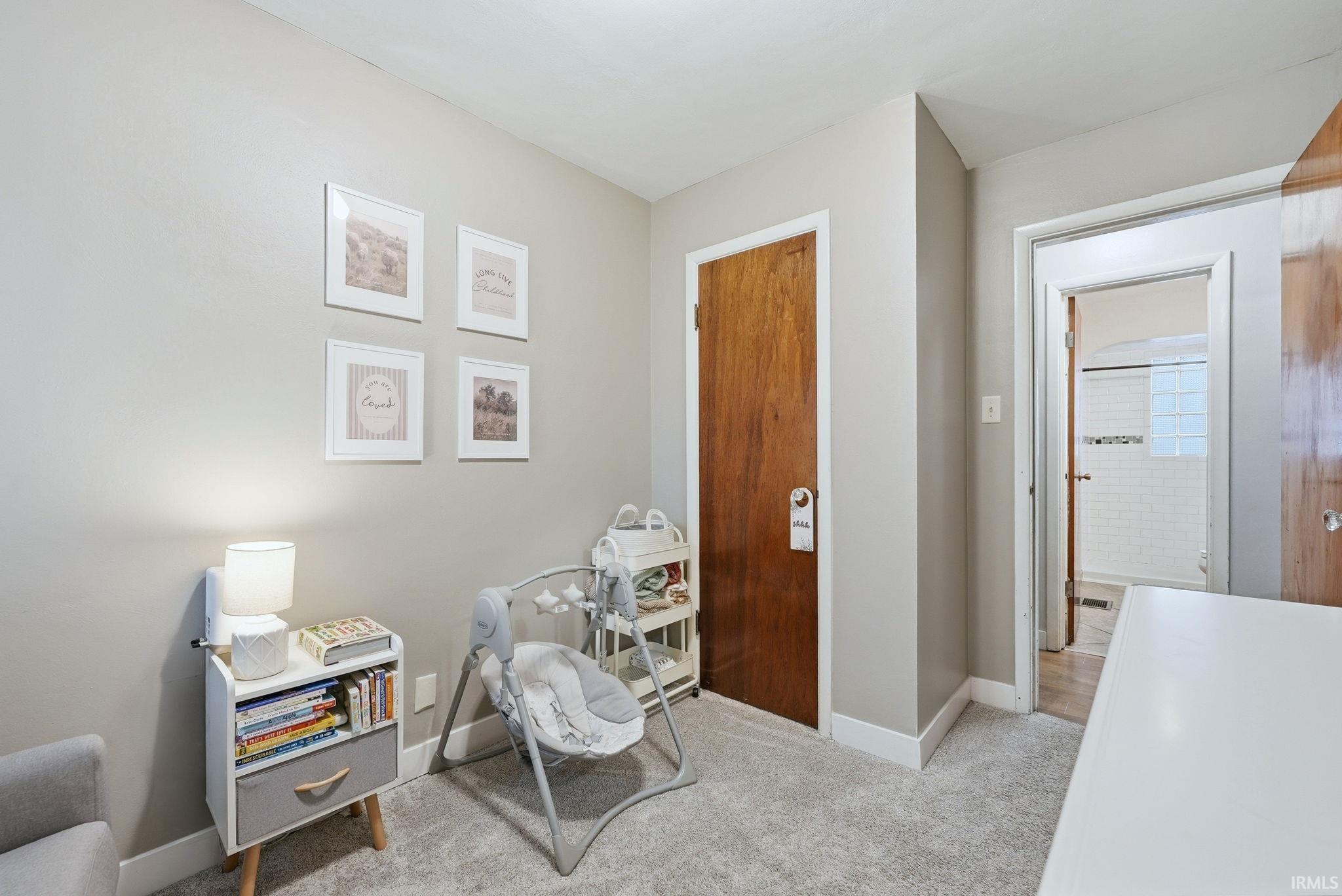 Living area with light colored carpet and baseboards