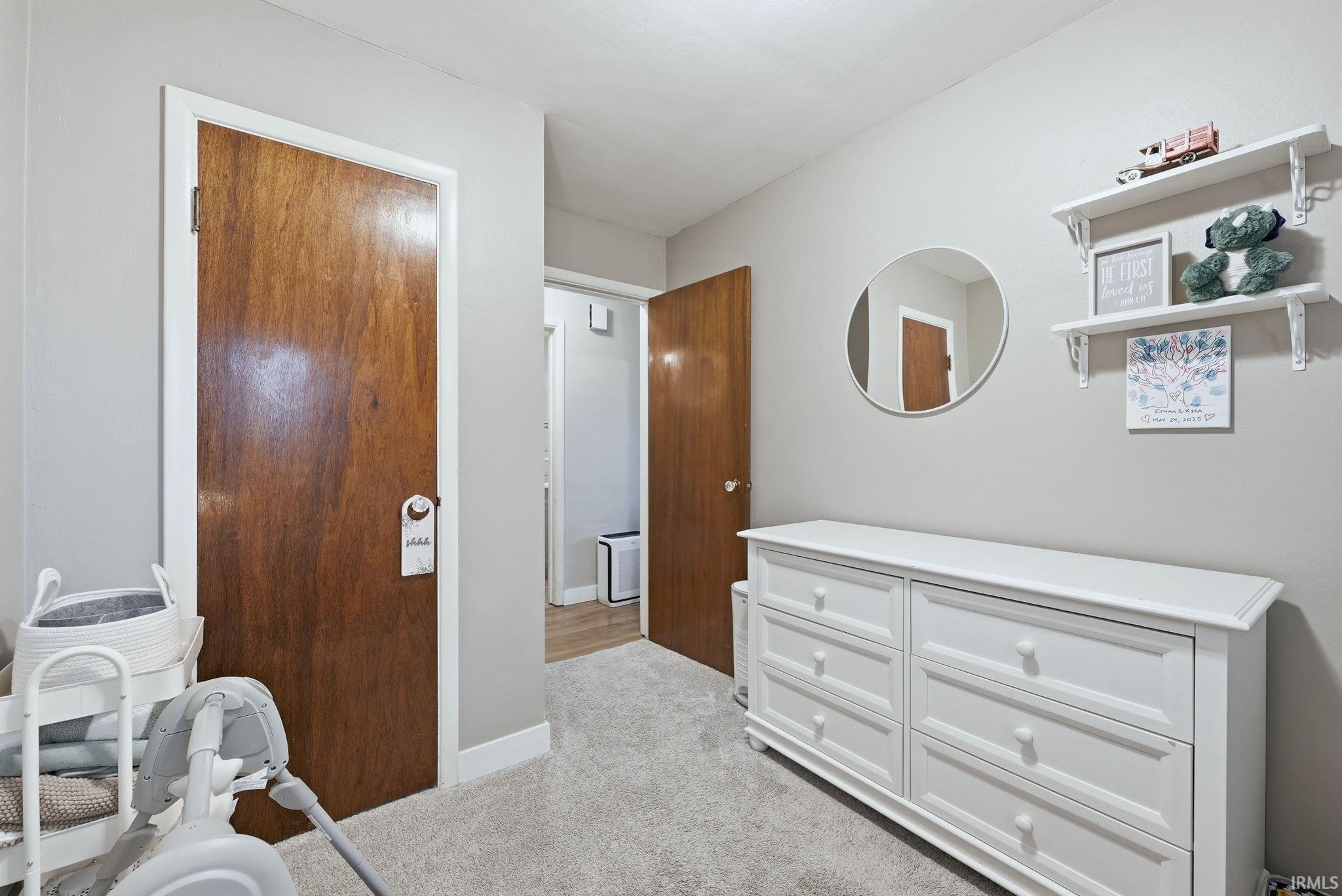 Bedroom featuring light colored carpet and baseboards