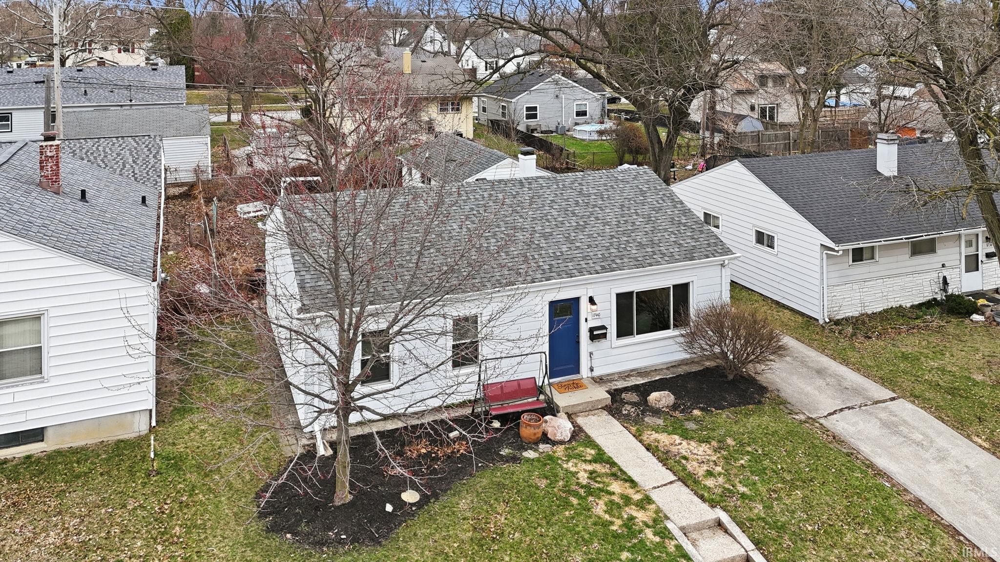 View of front of home with a shingled roof, a residential view, and a front lawn