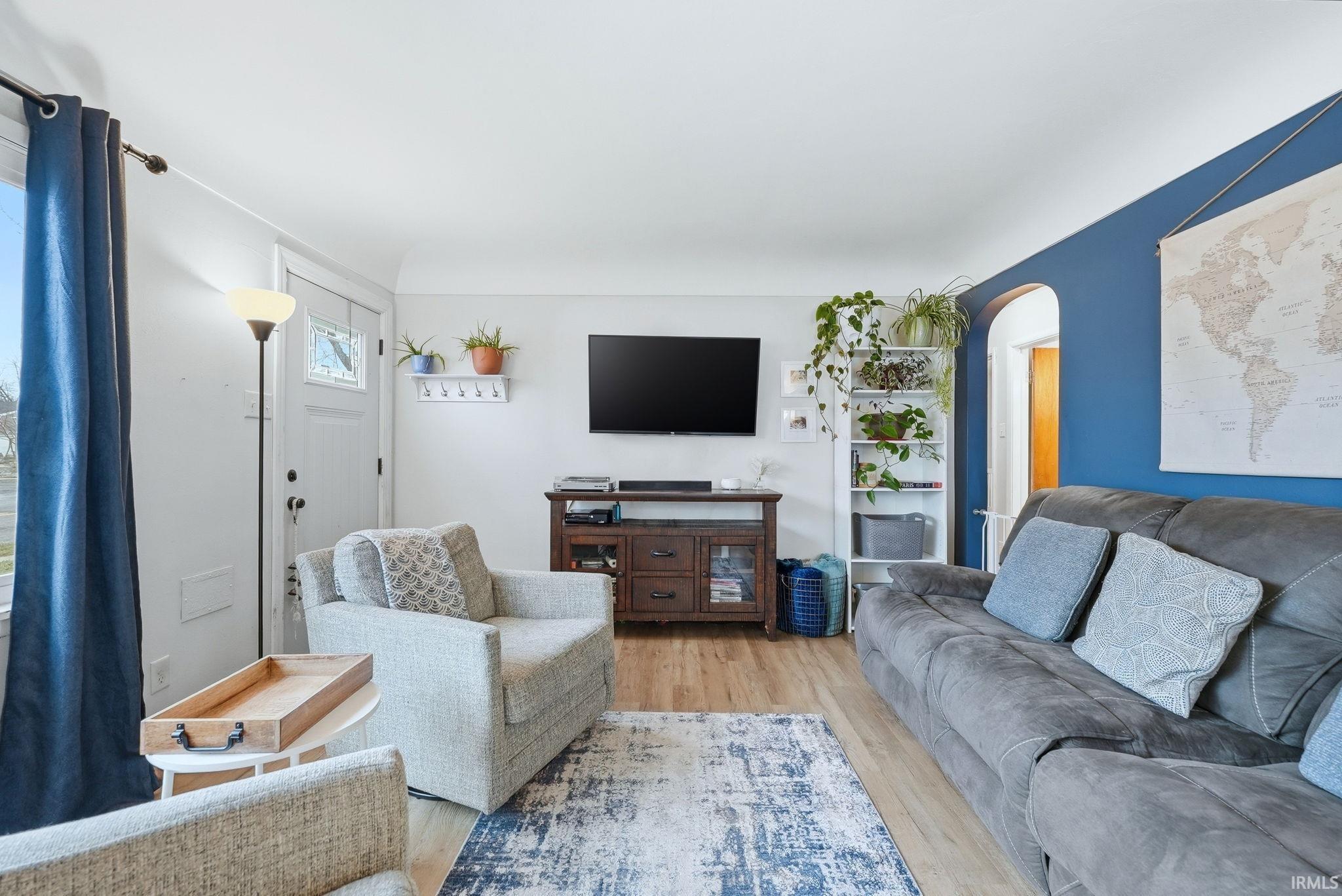 Living area with light wood-type flooring and arched walkways