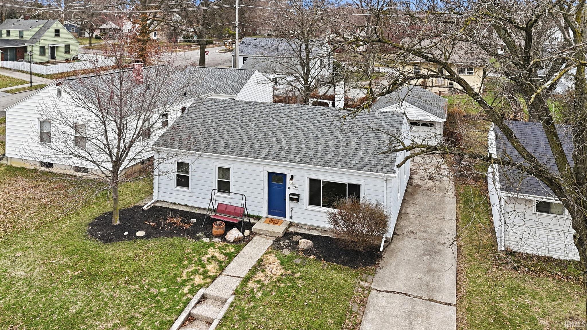 View of front of property featuring a shingled roof, a residential view, and a front yard