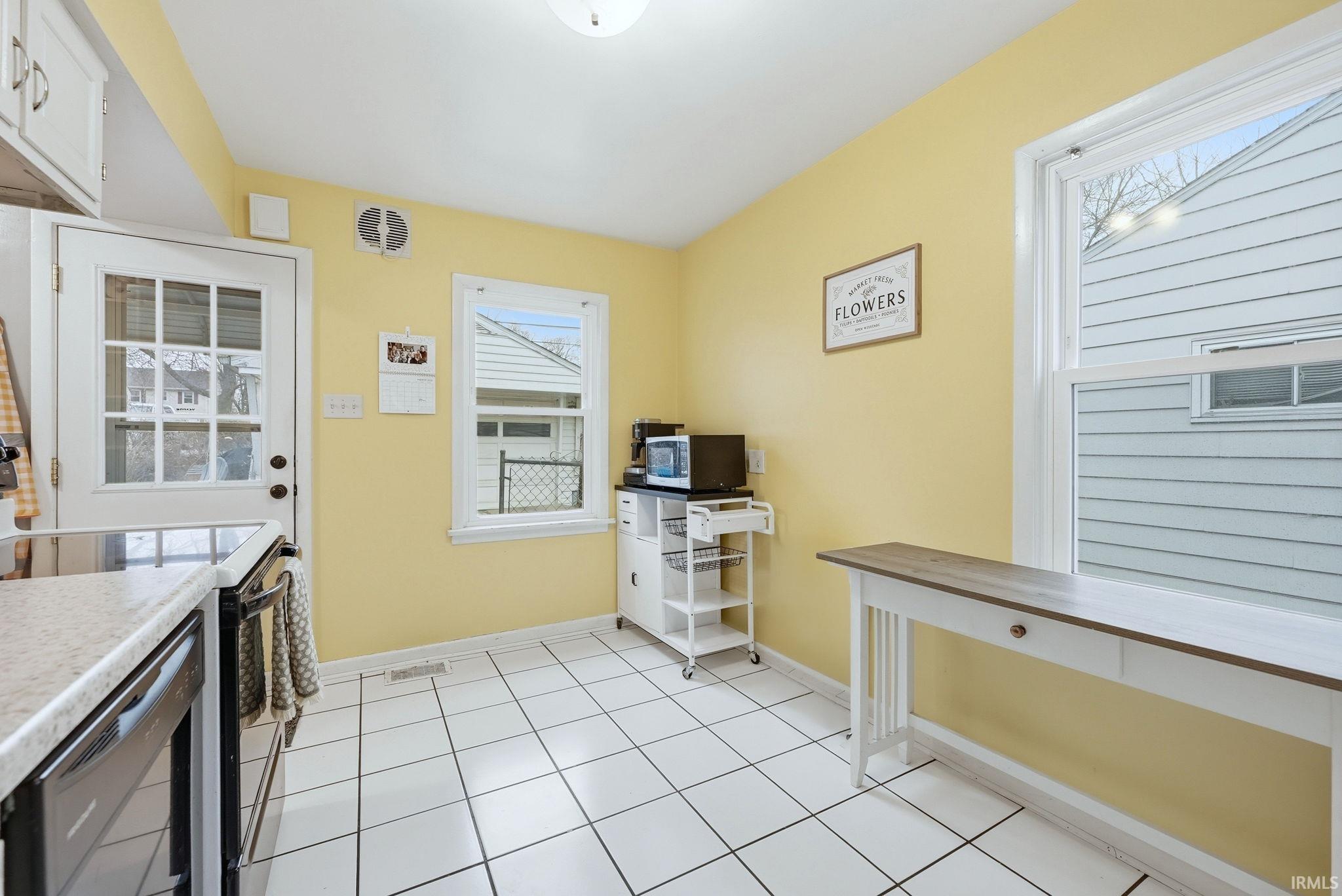 Kitchen with electric range, light countertops, and light tile patterned flooring