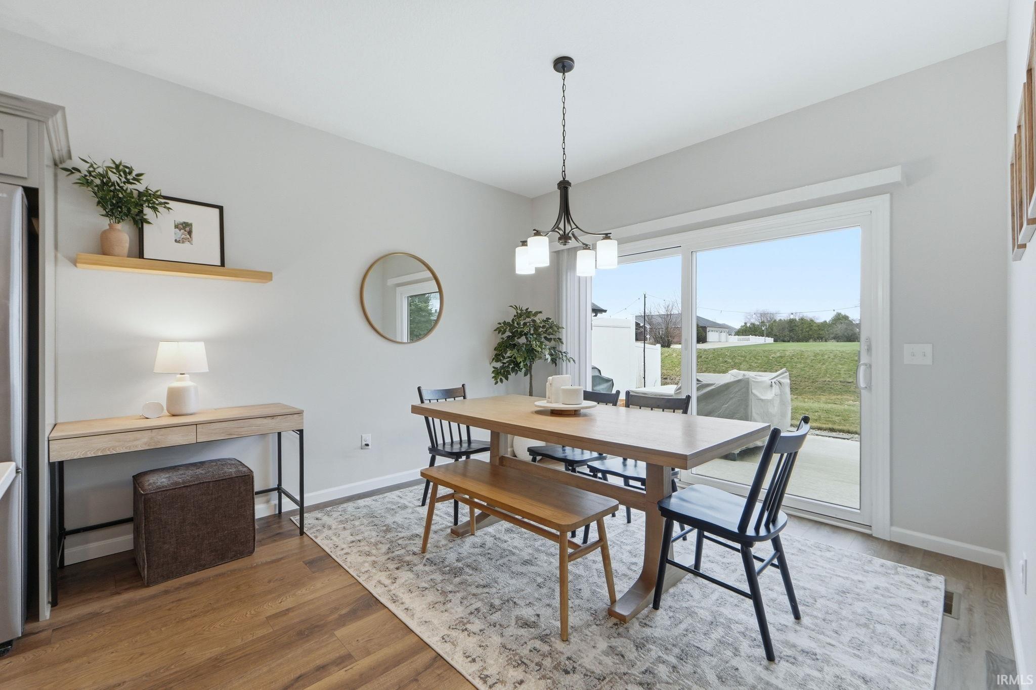 Dining room with suspended lighting and light wood-style flooring