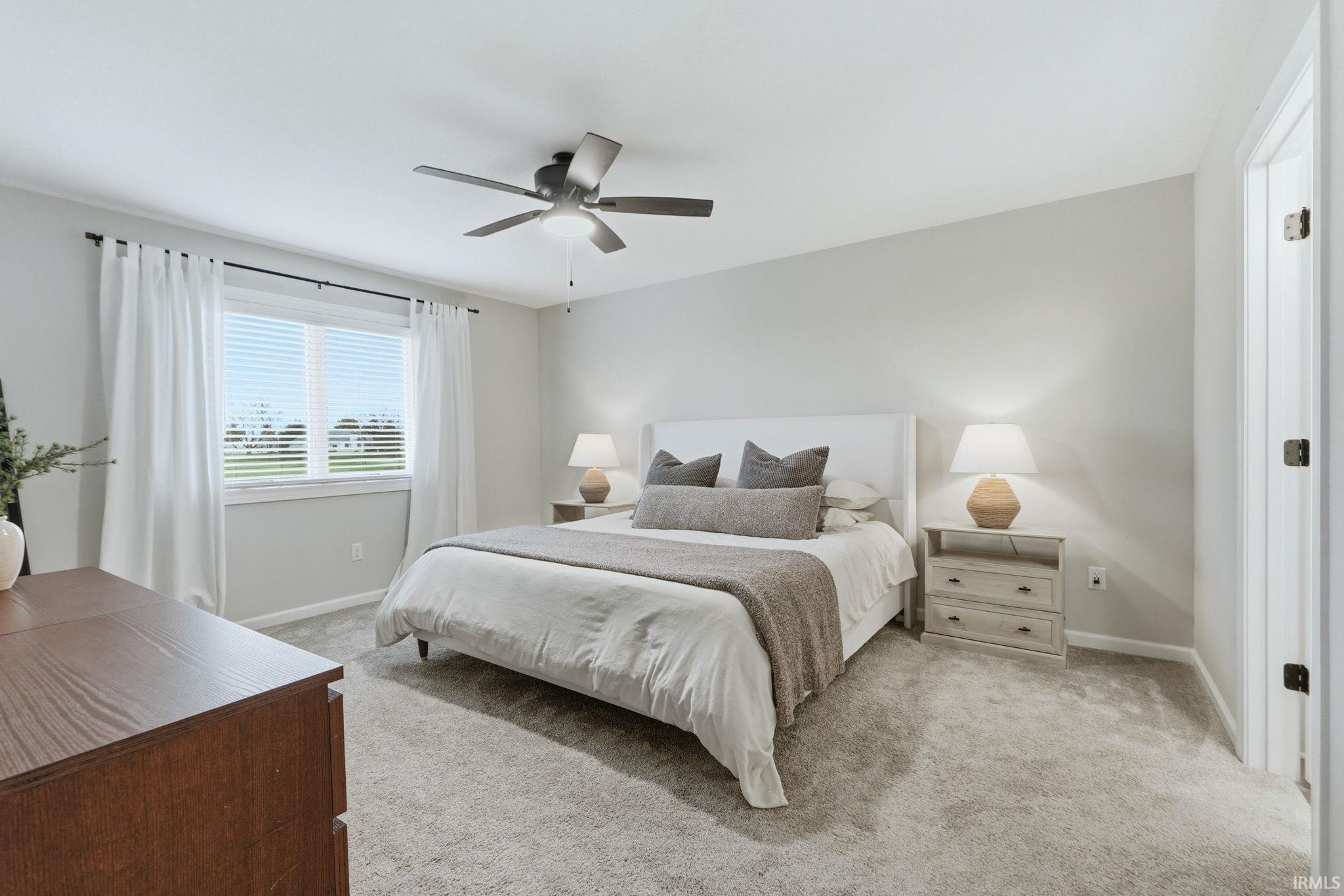 Bedroom featuring light colored carpet and ceiling fan
