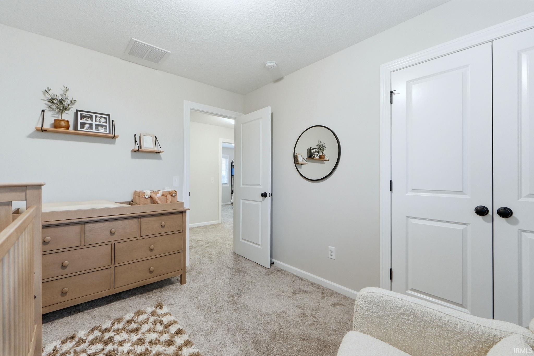 Living area with light colored carpet and a textured ceiling