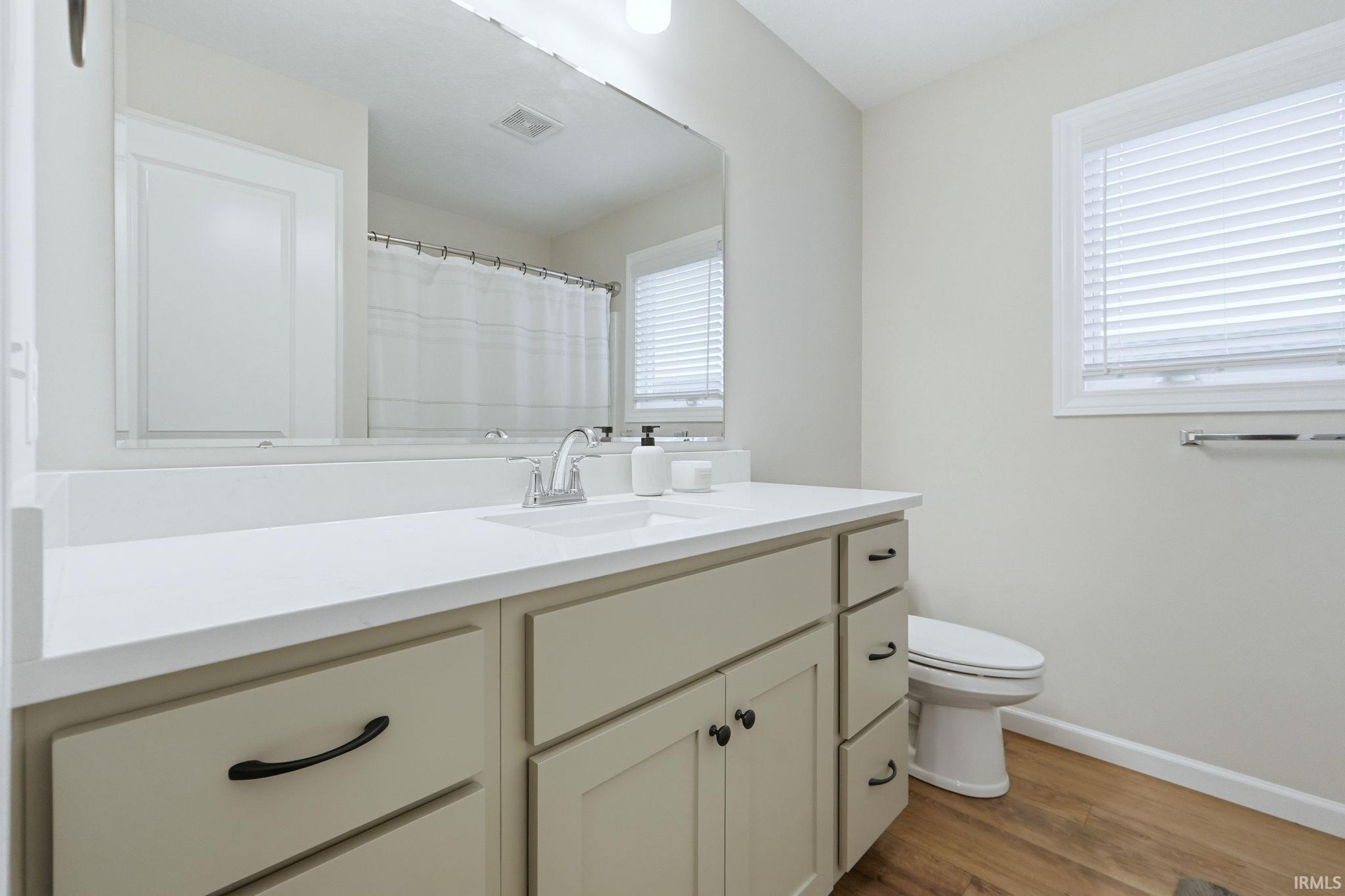 Bathroom featuring vanity, light wood finished floors, and a shower with shower curtain
