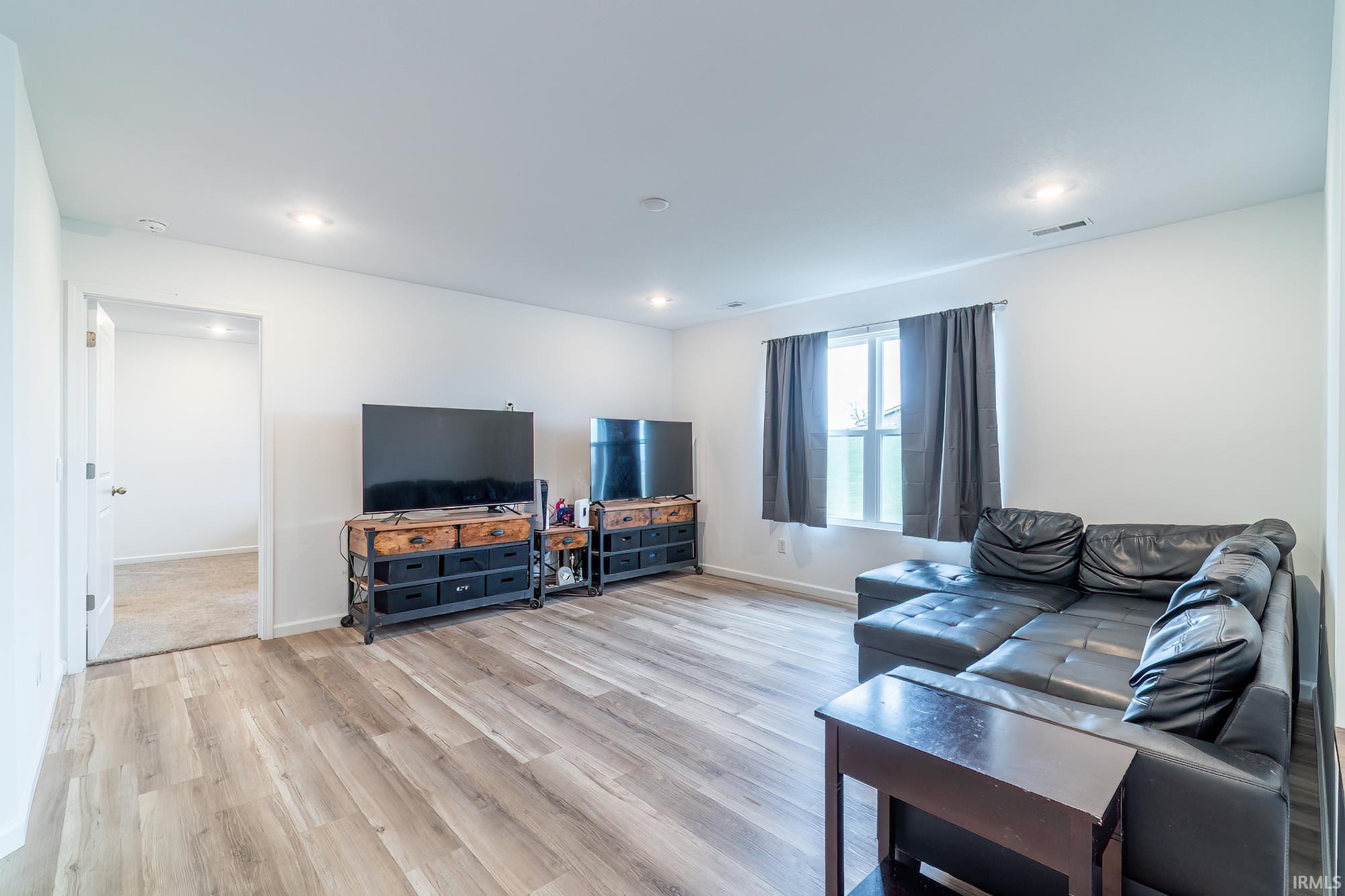 Living room featuring light wood finished floors and recessed lighting