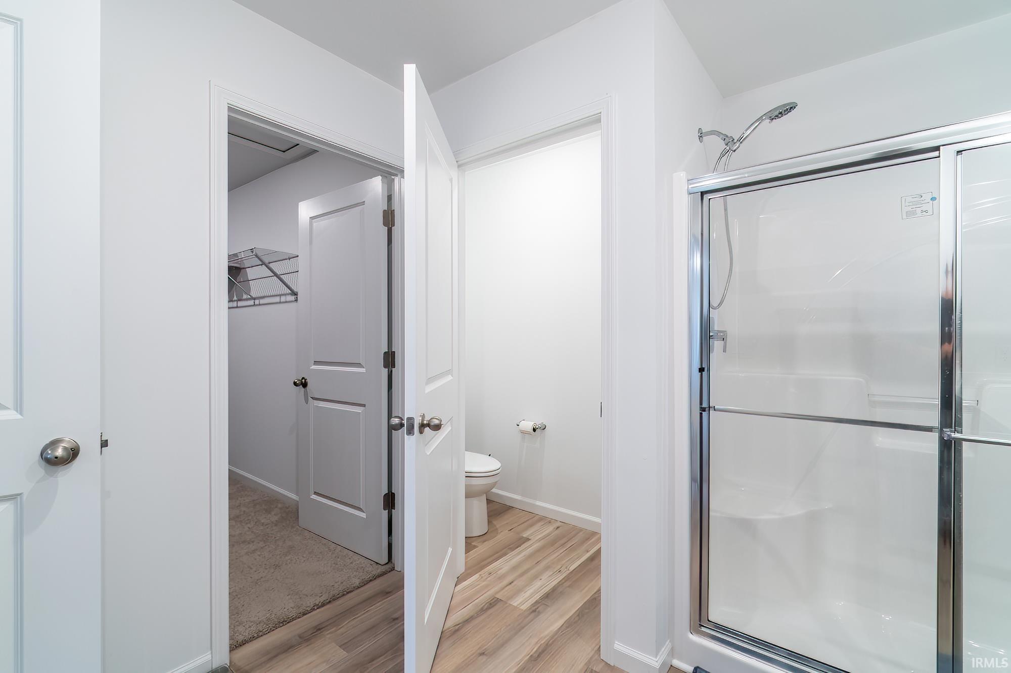 Bathroom featuring a shower stall and light wood-type flooring