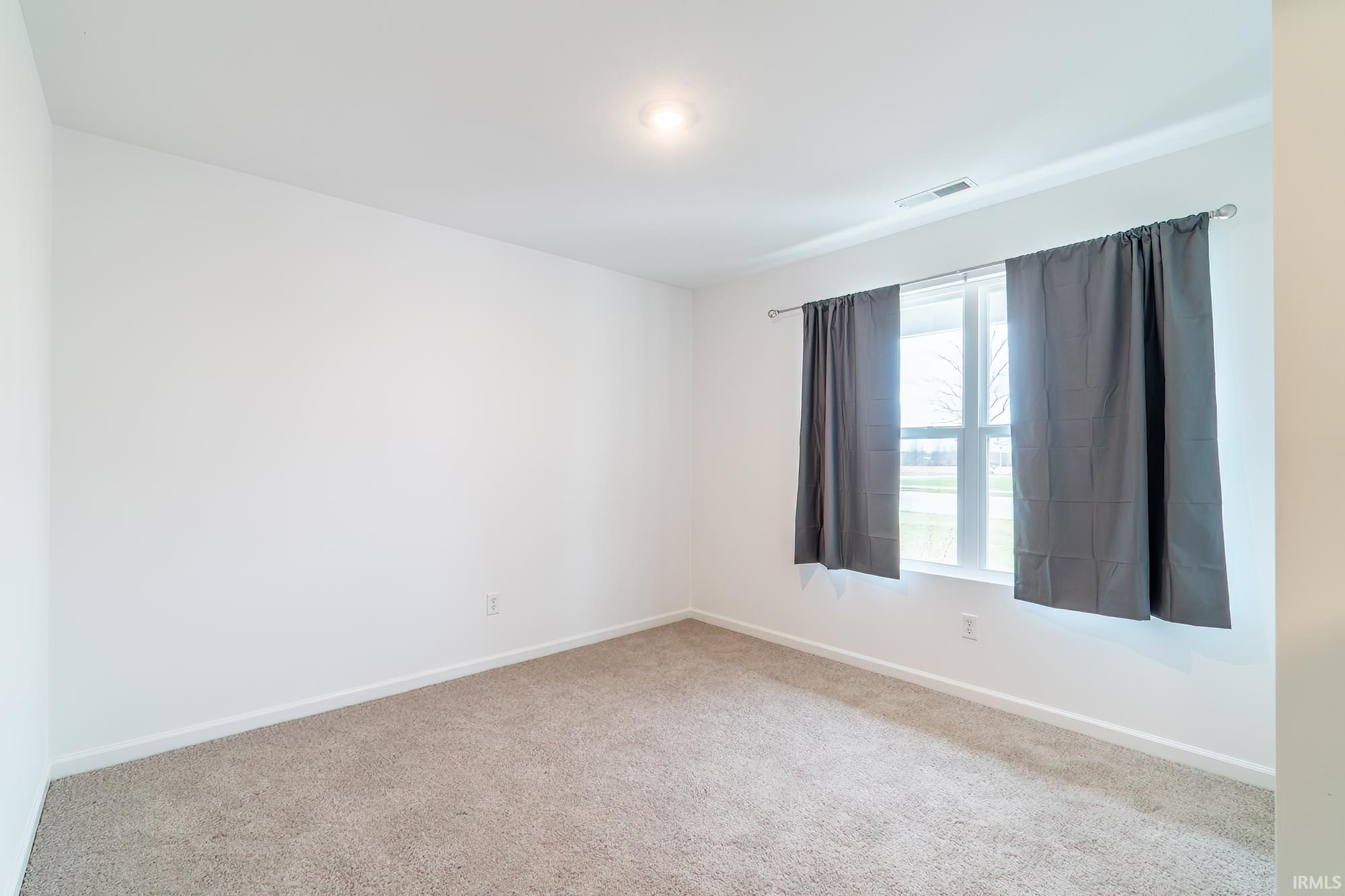 Carpeted empty room with baseboards