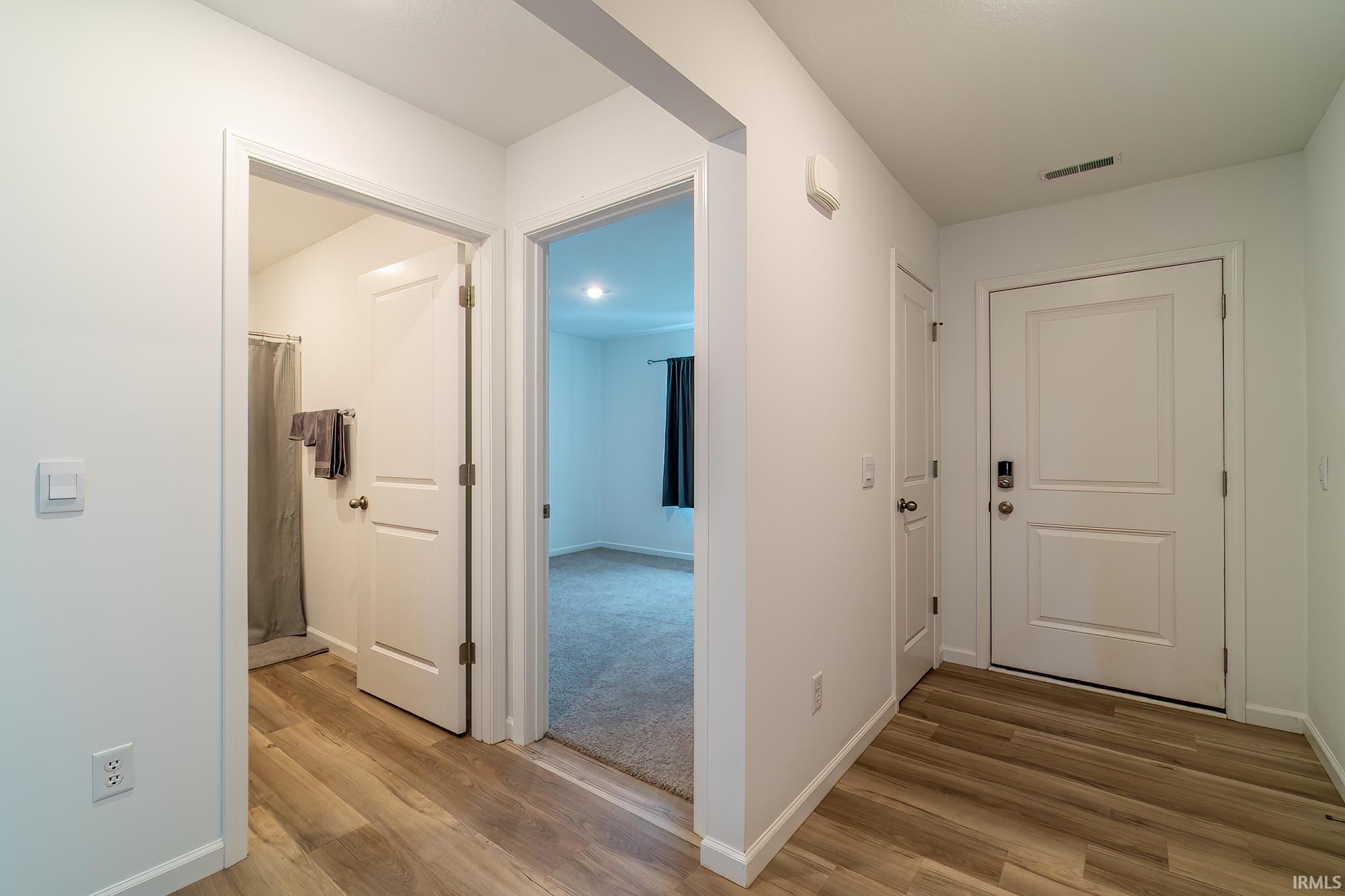 Corridor featuring light wood-style floors and baseboards