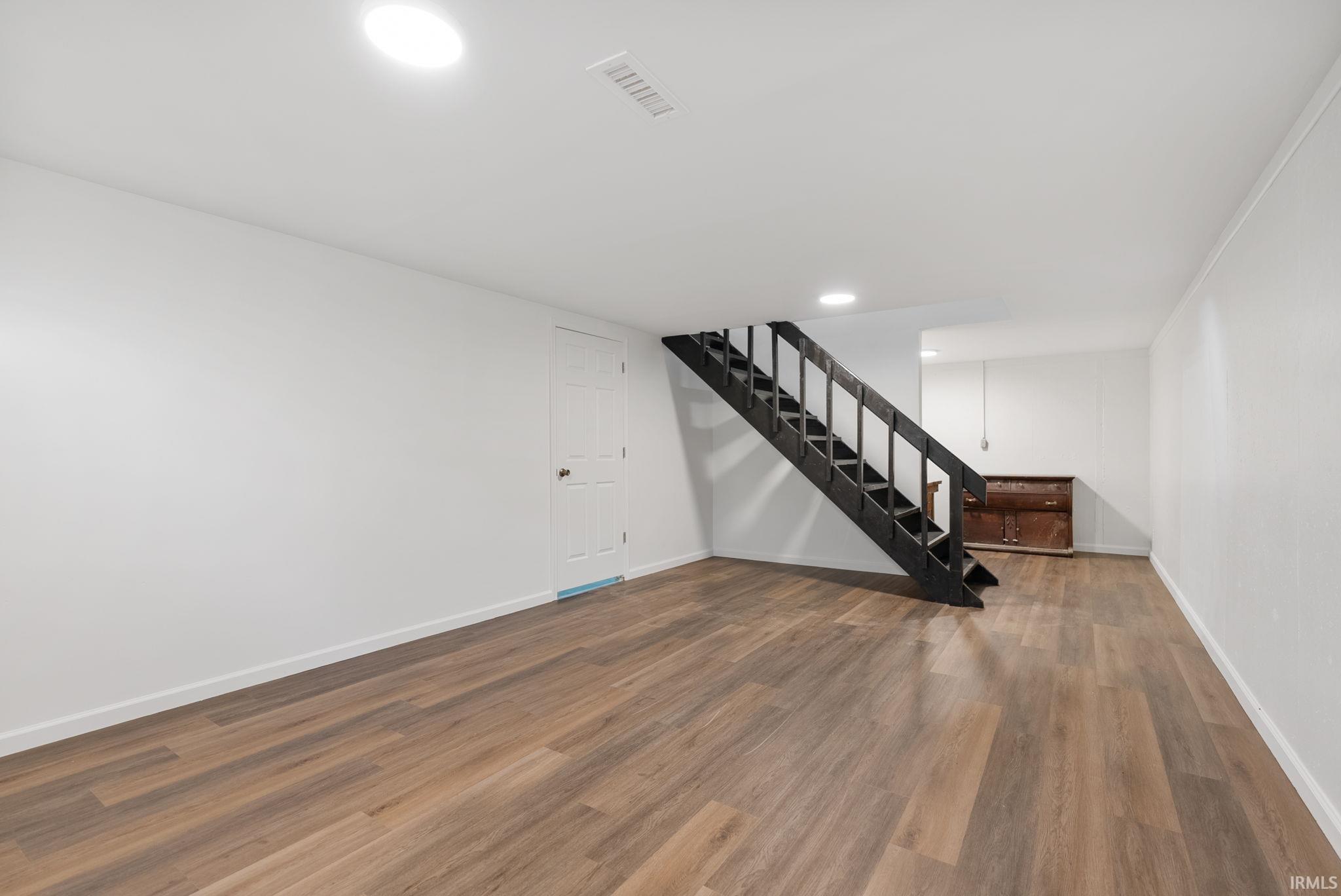 Unfurnished living room with dark wood-type flooring and recessed lighting
