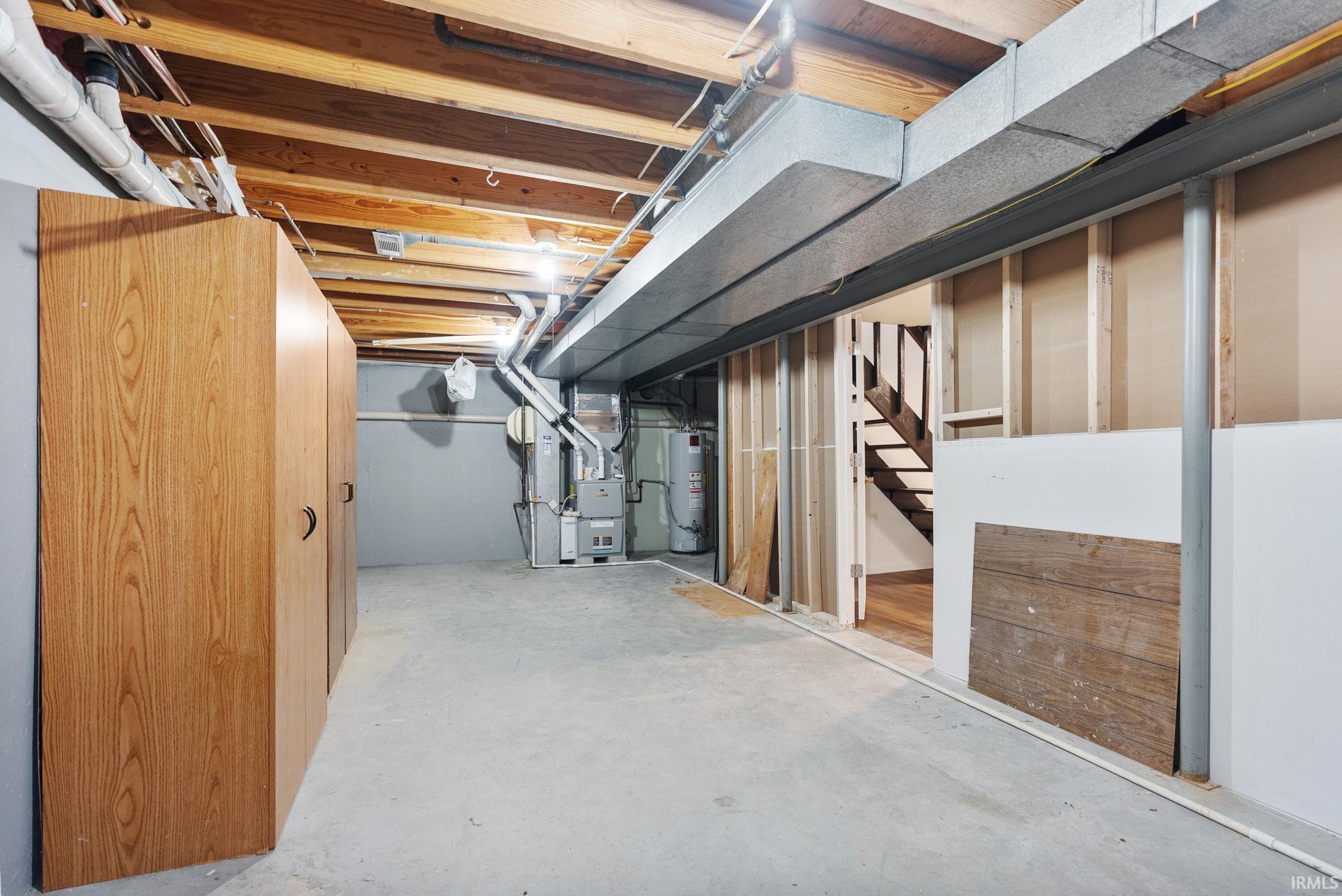 Unfinished basement with heating unit and gas water heater