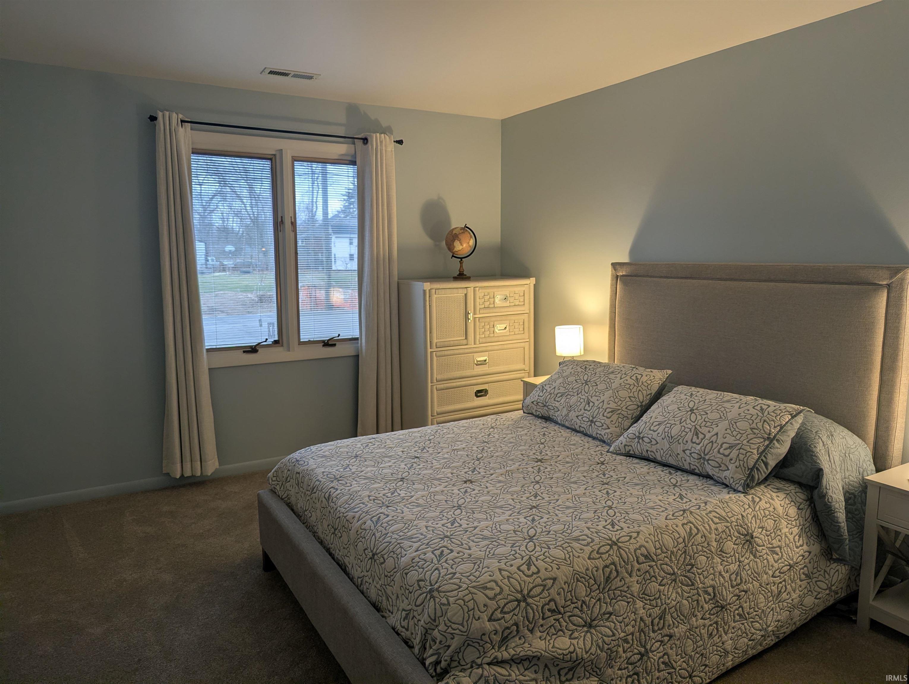 Bedroom featuring dark colored carpet and baseboards