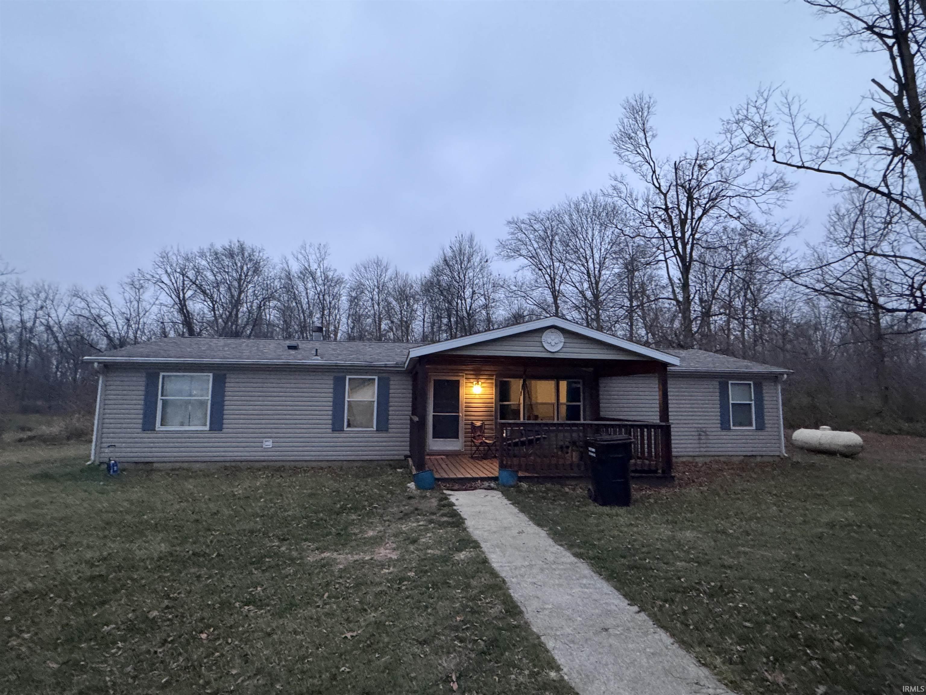 Single story home featuring a front yard and a wooden deck