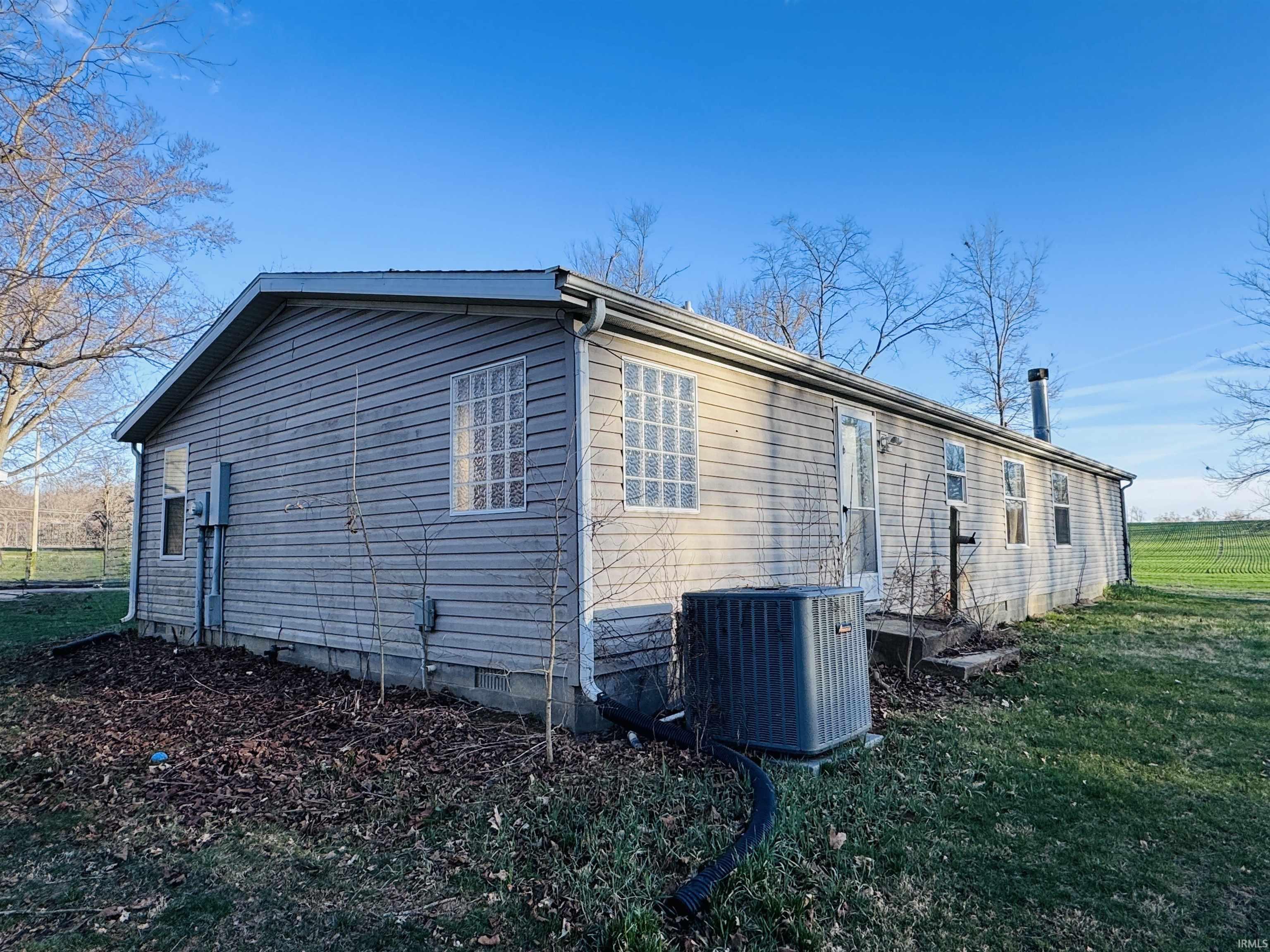 View of home's exterior with a central AC unit and a yard