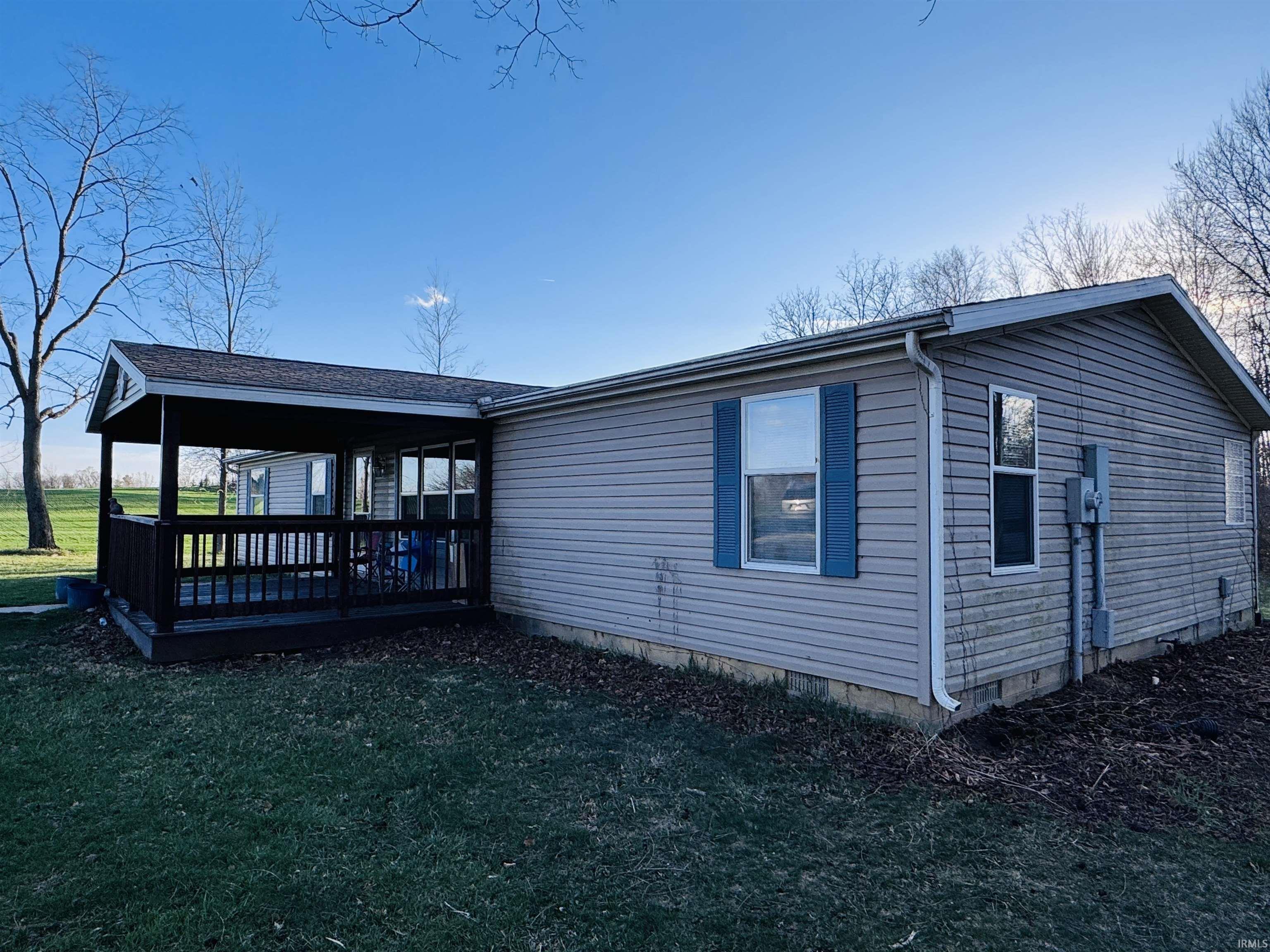 View of side of property with a lawn and a deck