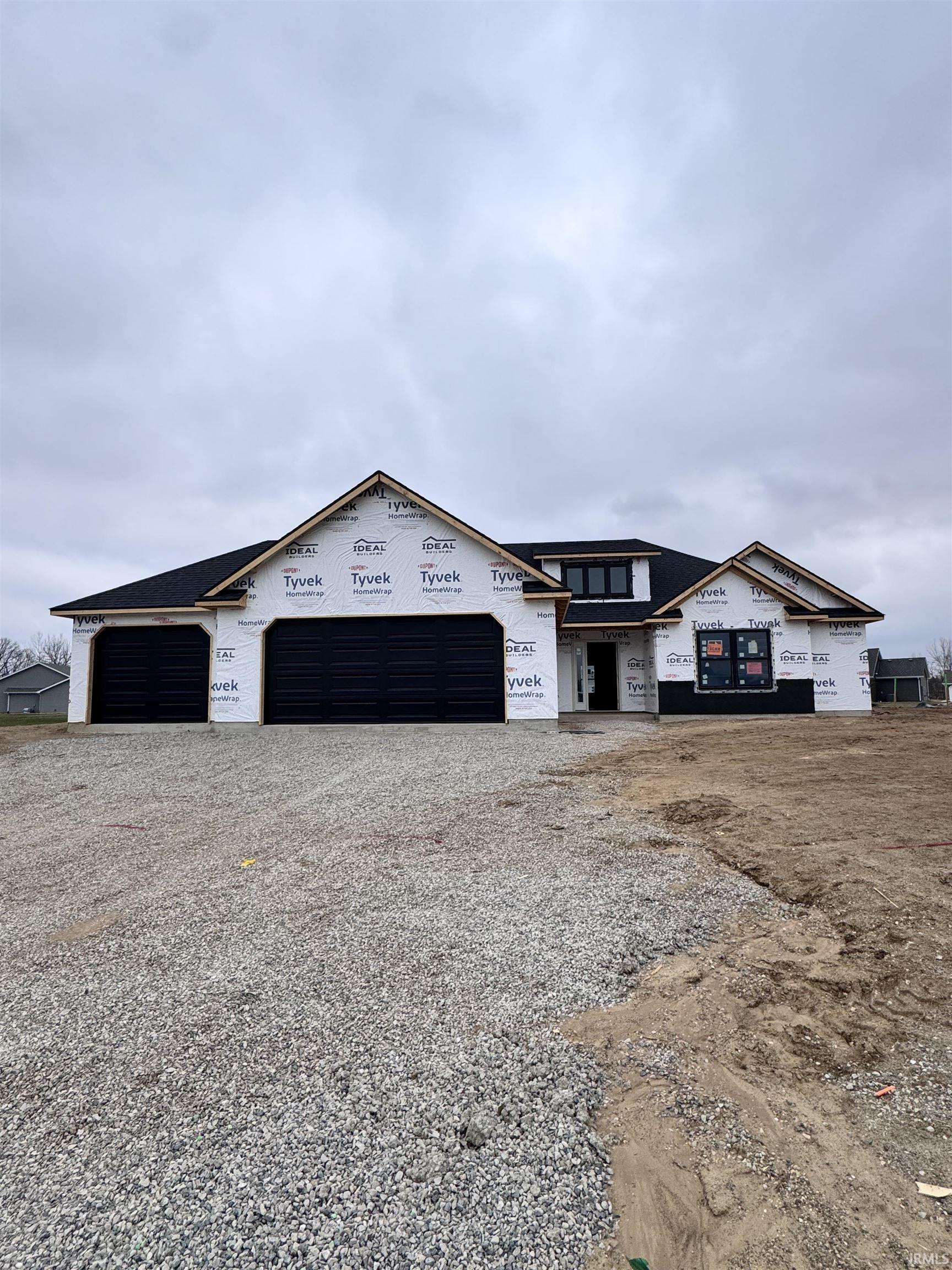 Property under construction with driveway and a garage