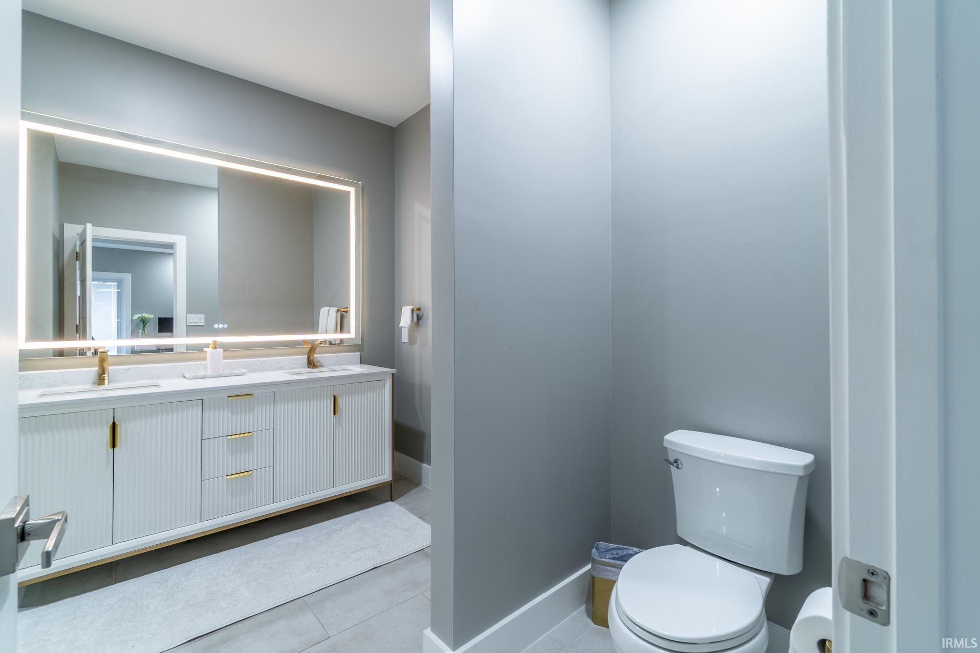 Full bath with double vanity and light tile patterned floors