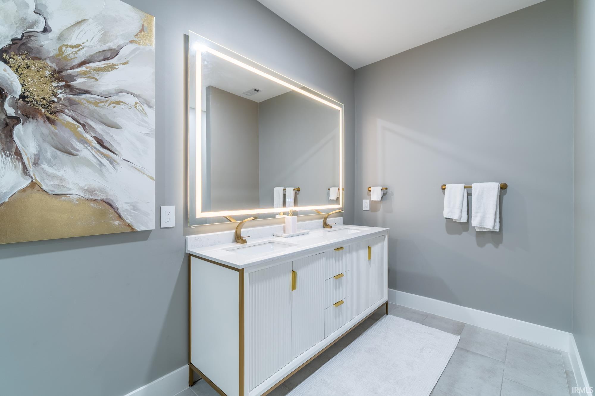 Bathroom featuring double vanity and light tile patterned flooring
