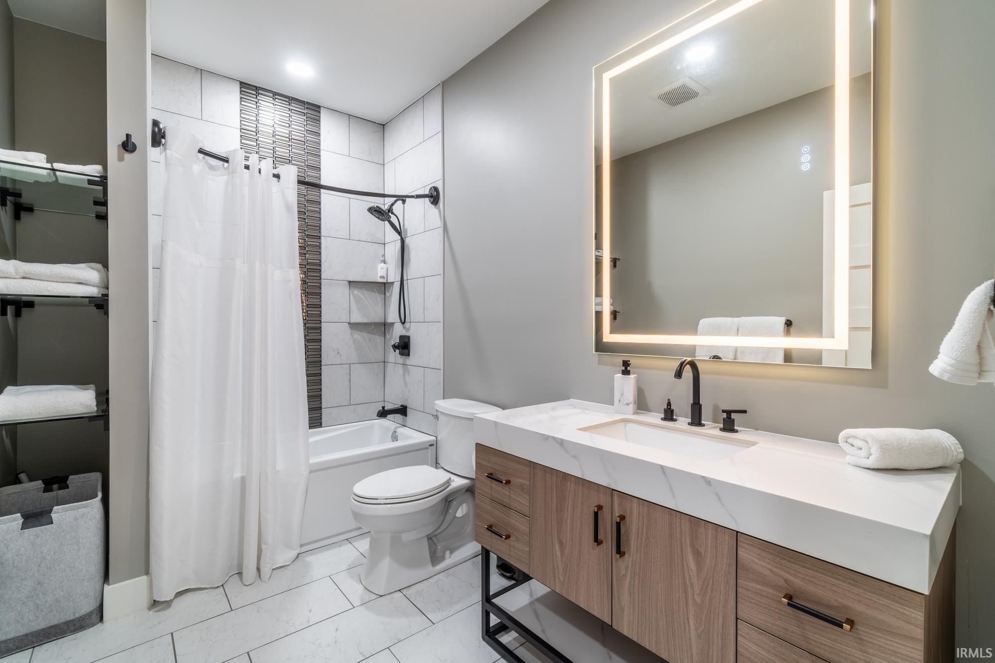 Full bath featuring vanity and shower / bath combo