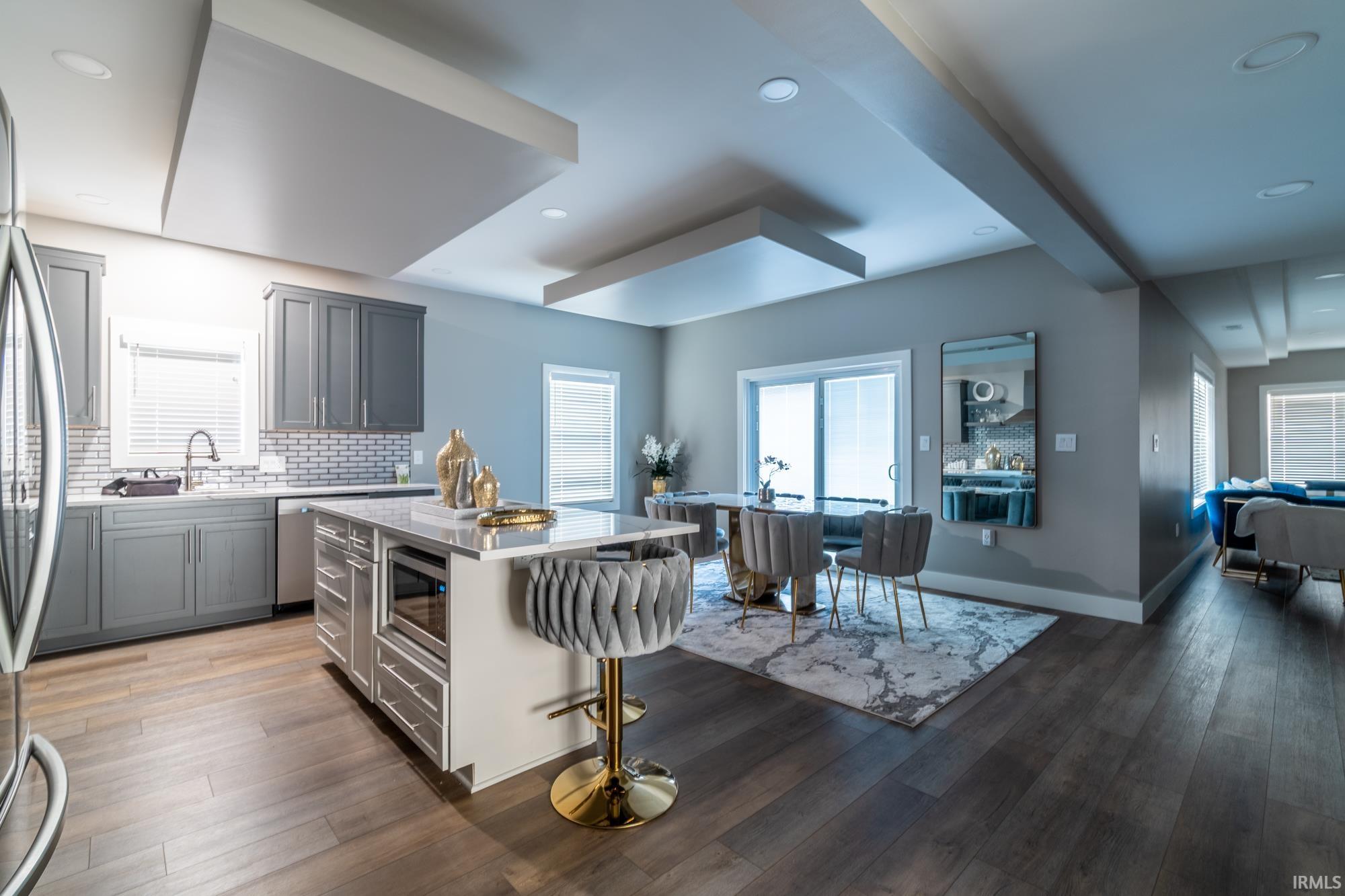 Kitchen with a kitchen breakfast bar, a kitchen island, backsplash, dark wood finished floors, and recessed lighting
