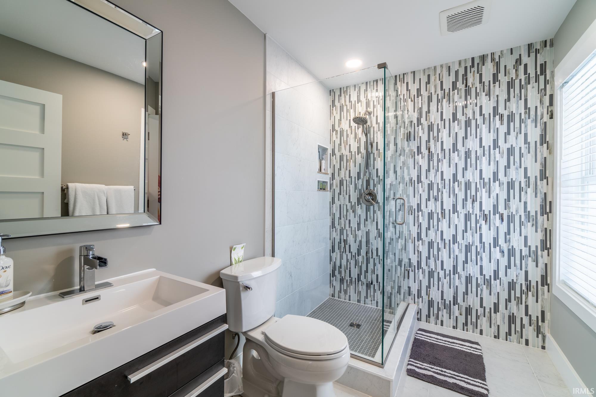 Bathroom with vanity, a shower stall, and recessed lighting