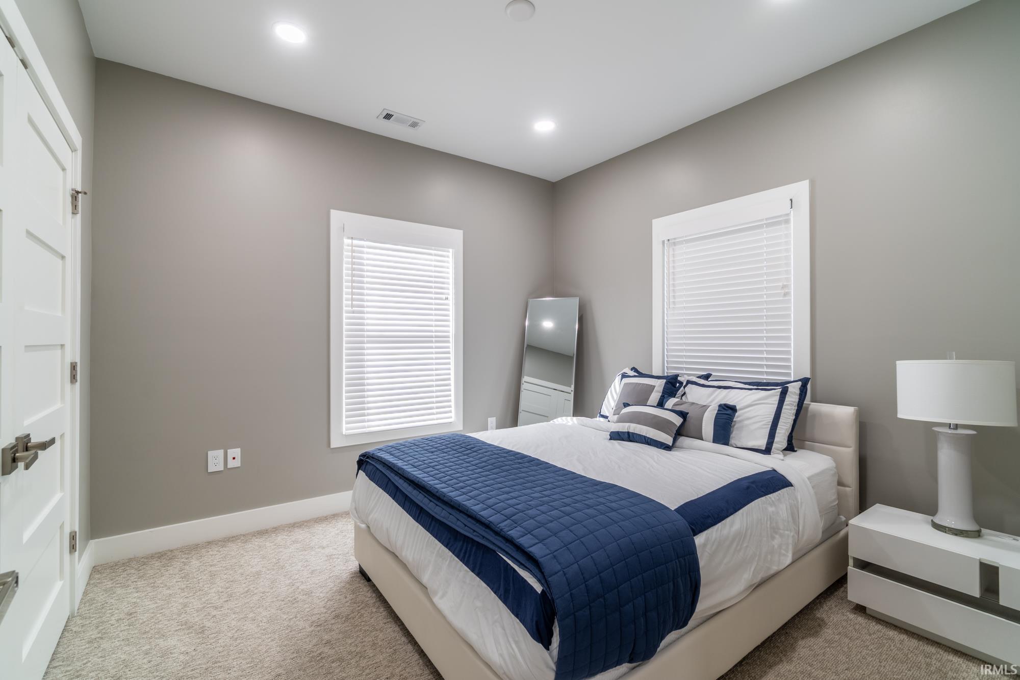 Bedroom with light carpet and recessed lighting