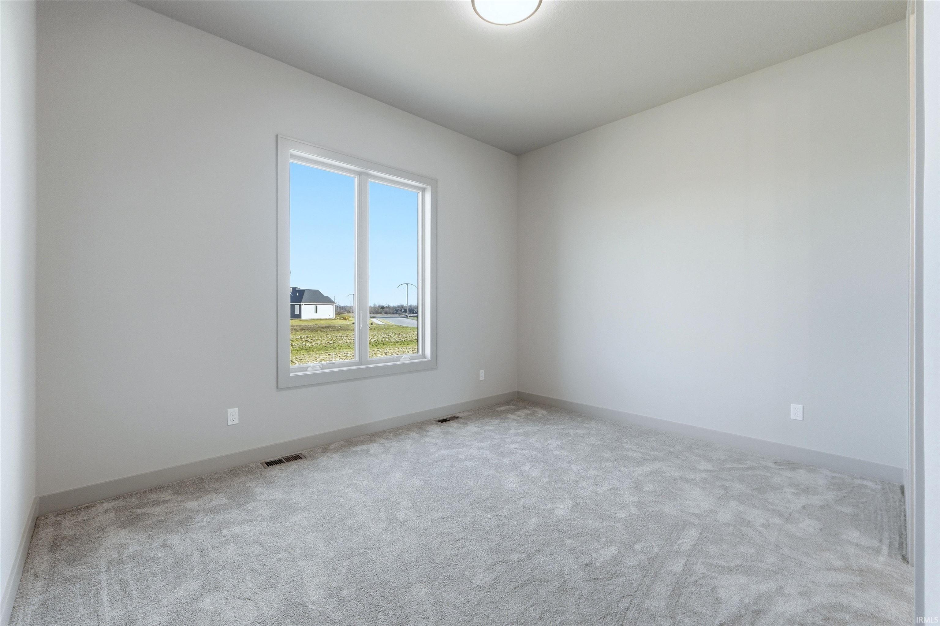 Spare room featuring carpet floors and baseboards