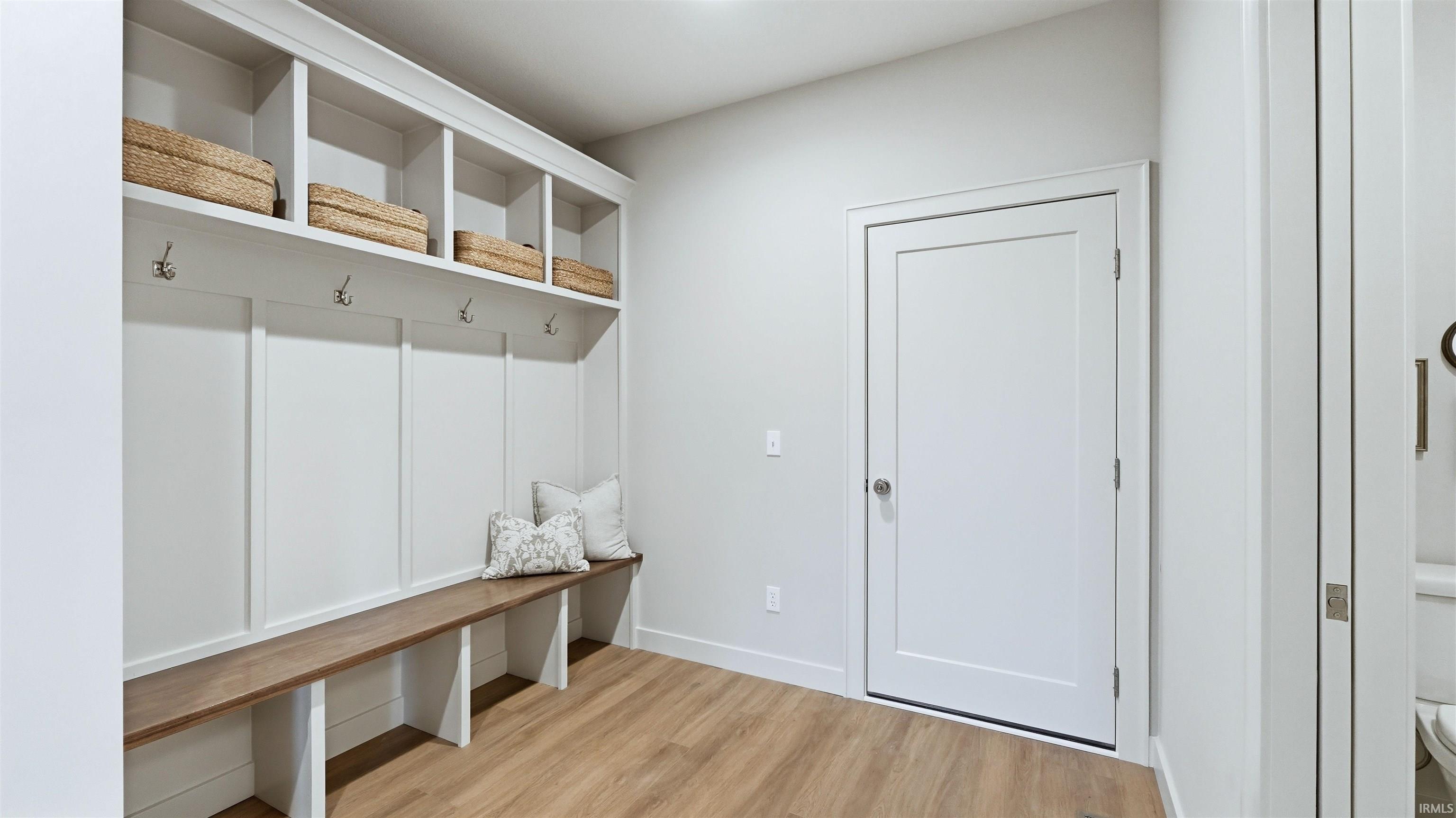 Mudroom featuring light wood-style floors and baseboards