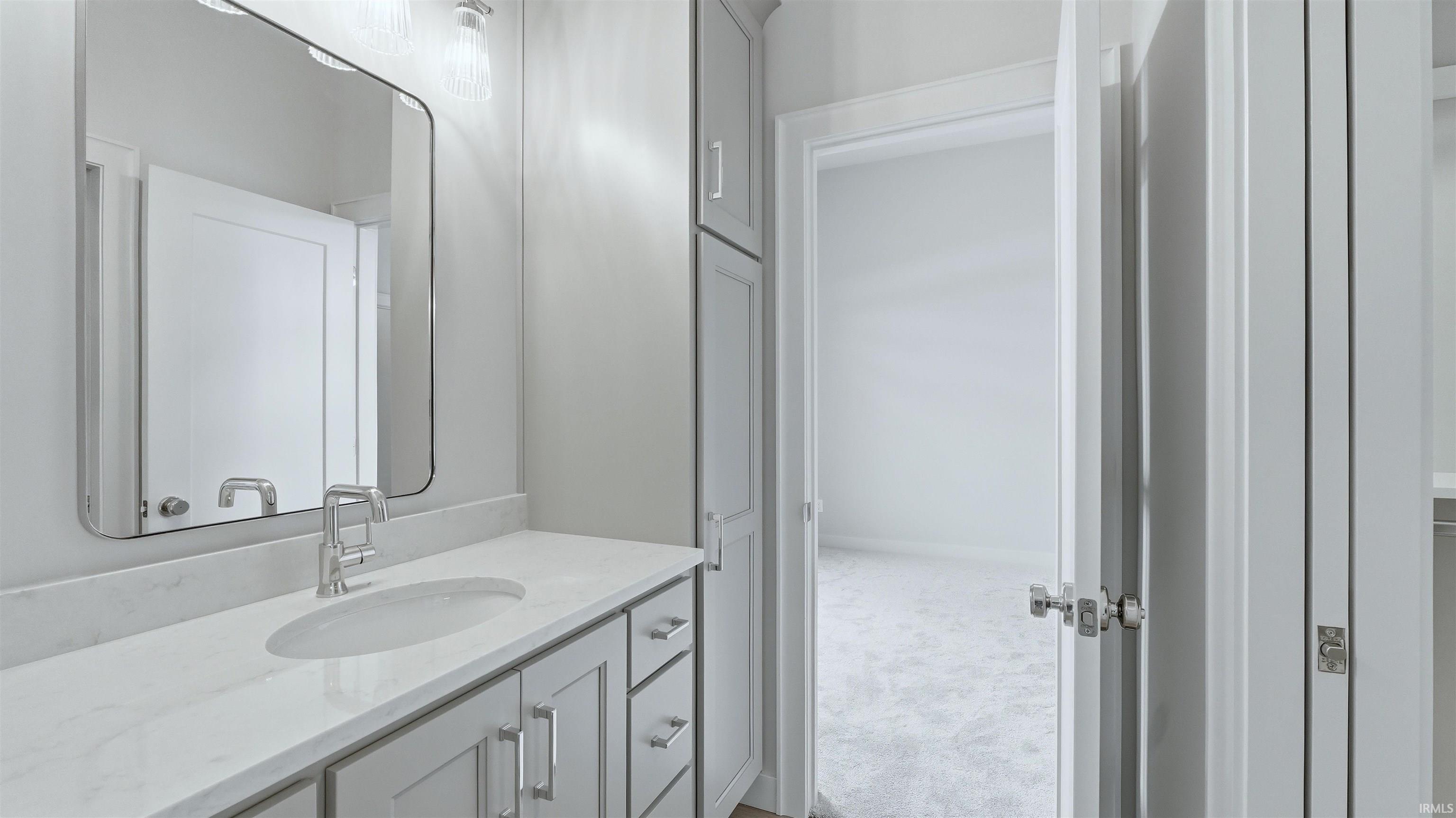 Bathroom with vanity and light carpet
