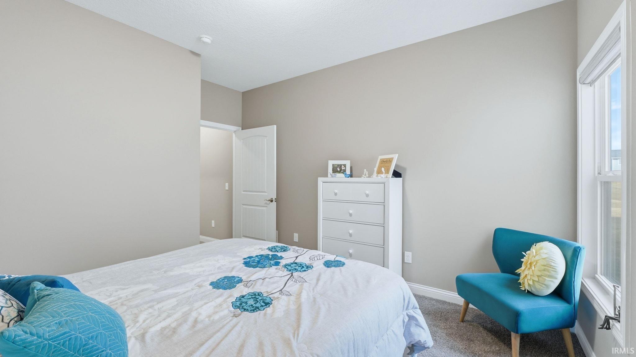Bedroom featuring baseboards and carpet