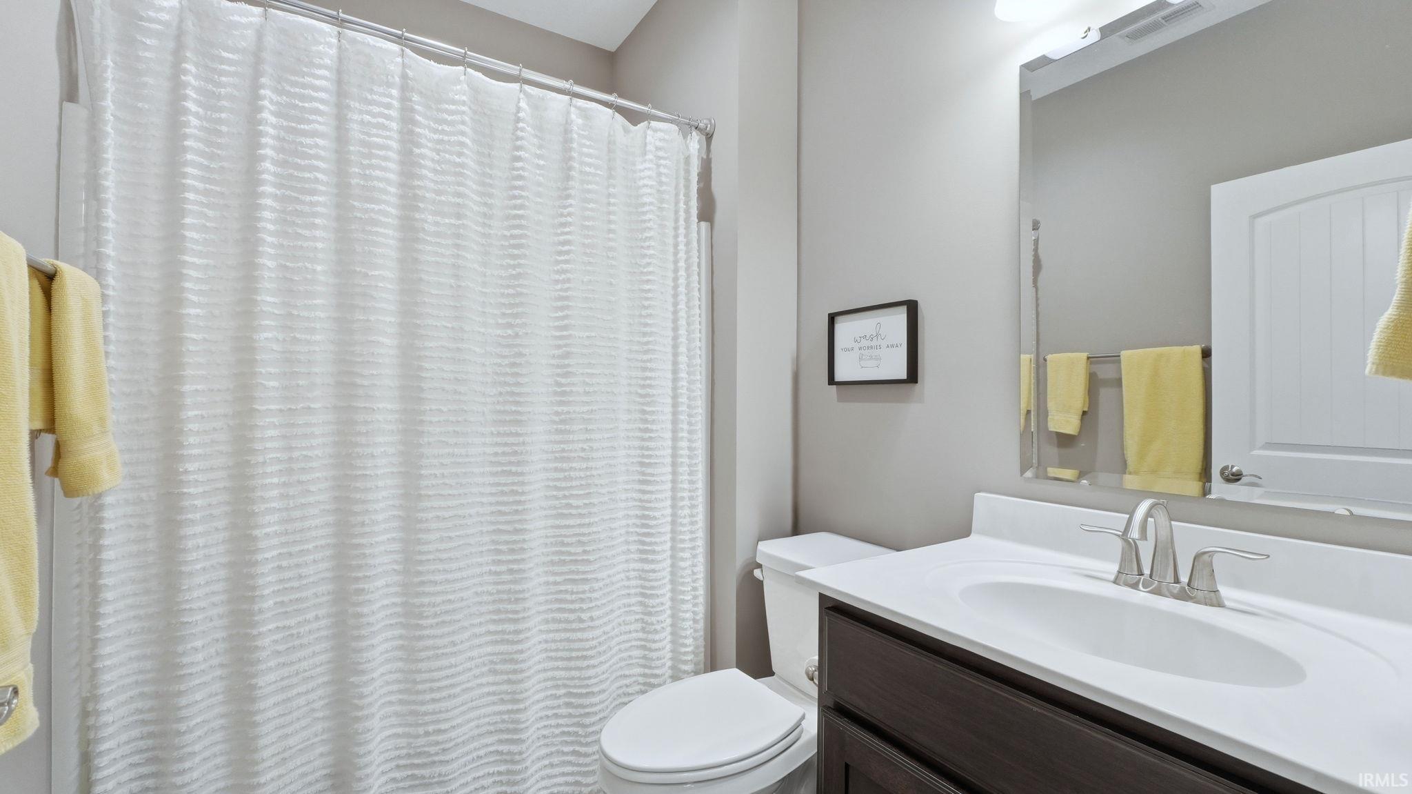 Full bath with vanity and a shower with shower curtain