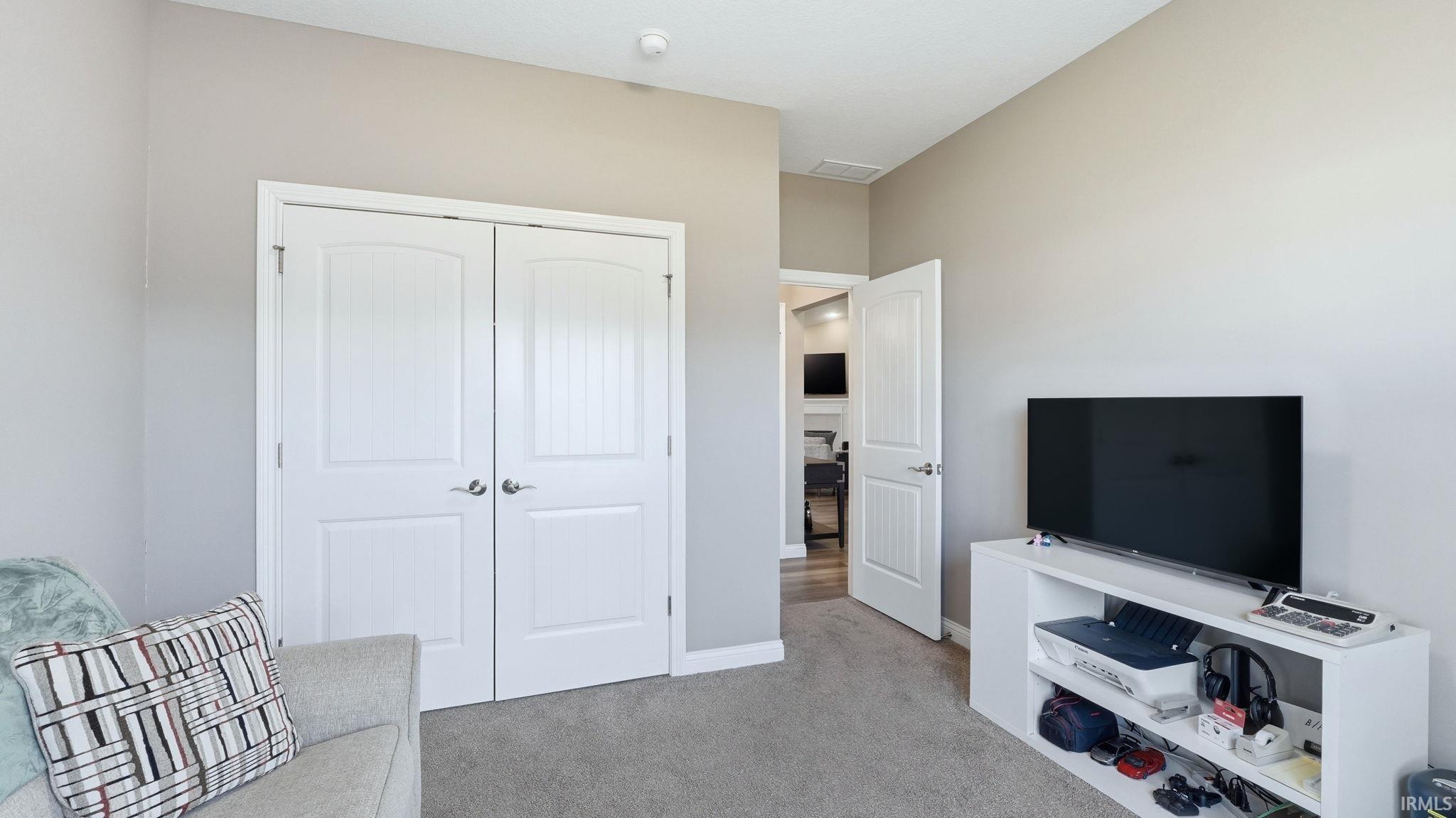 Sitting room featuring light colored carpet and baseboards