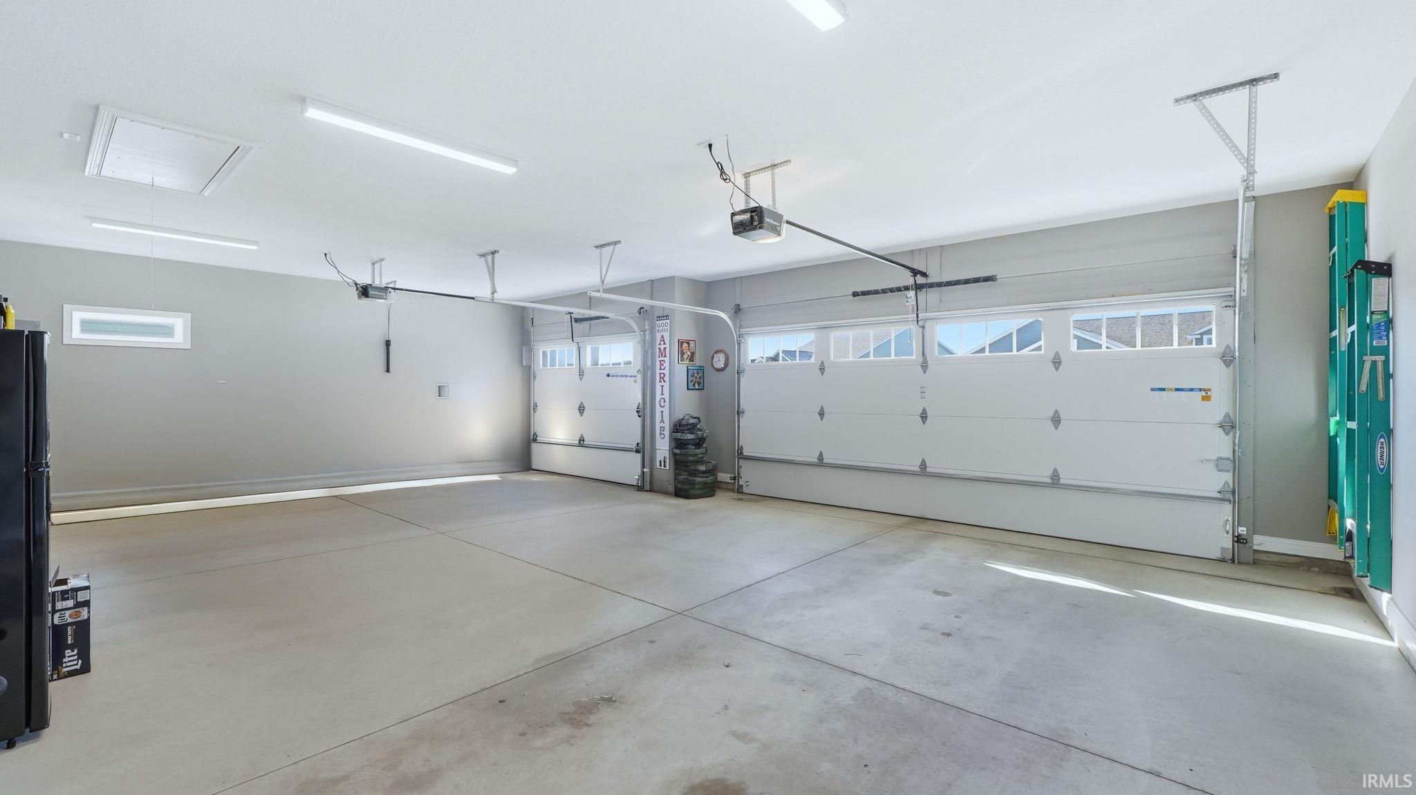 Garage featuring freestanding refrigerator and baseboards