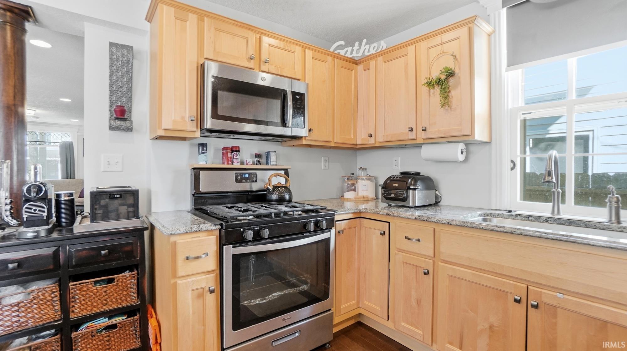Kitchen featuring light wood finish cabinets, stainless steel appliances, light stone countertops, and recessed lighting