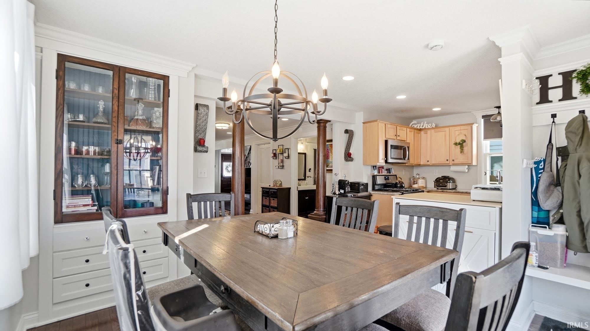 Dining space with a chandelier and crown molding